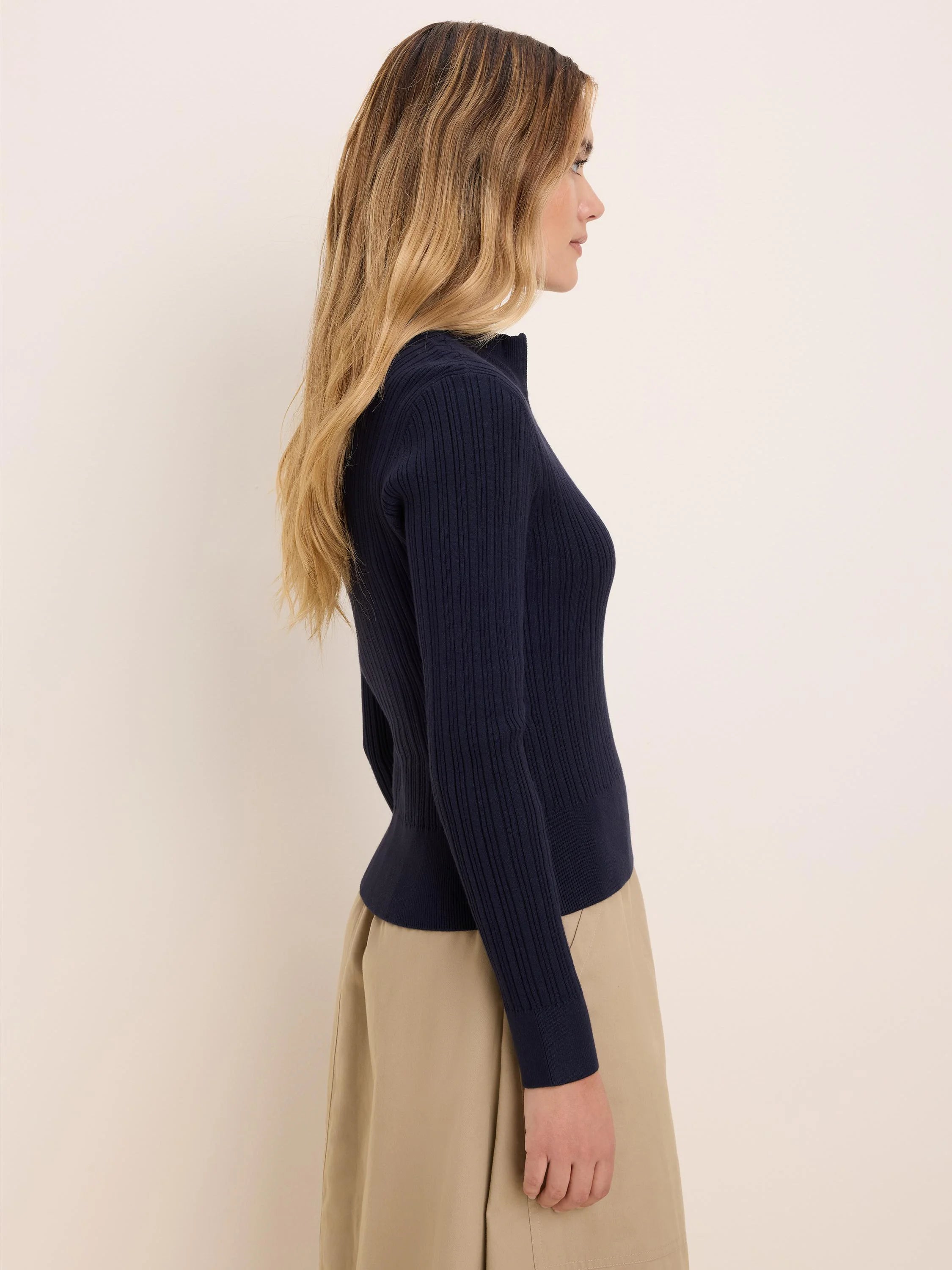 Navy blue ribbed half-zip sweater worn by model.