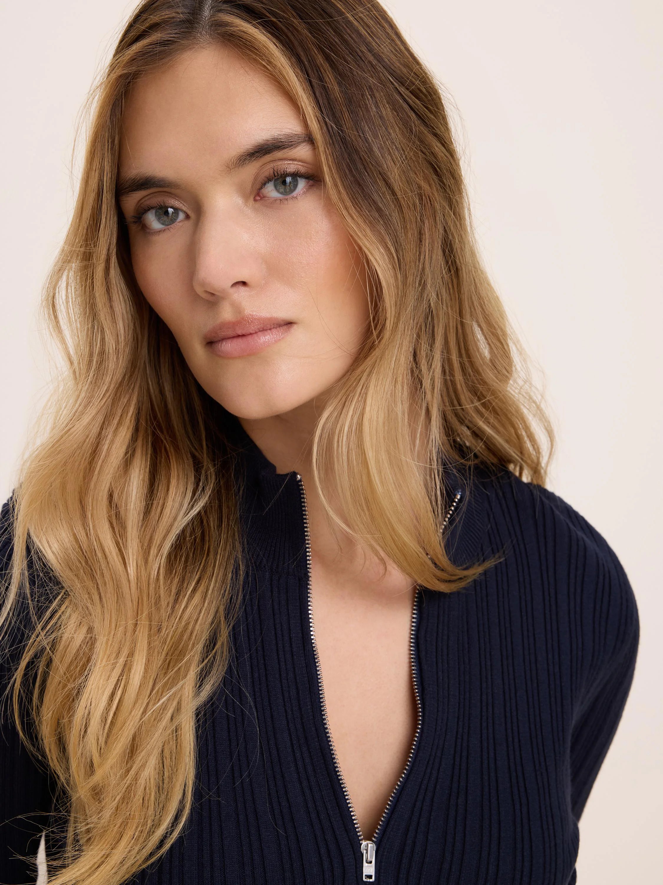 Dark blue half-zip ribbed sweater with silver zipper.