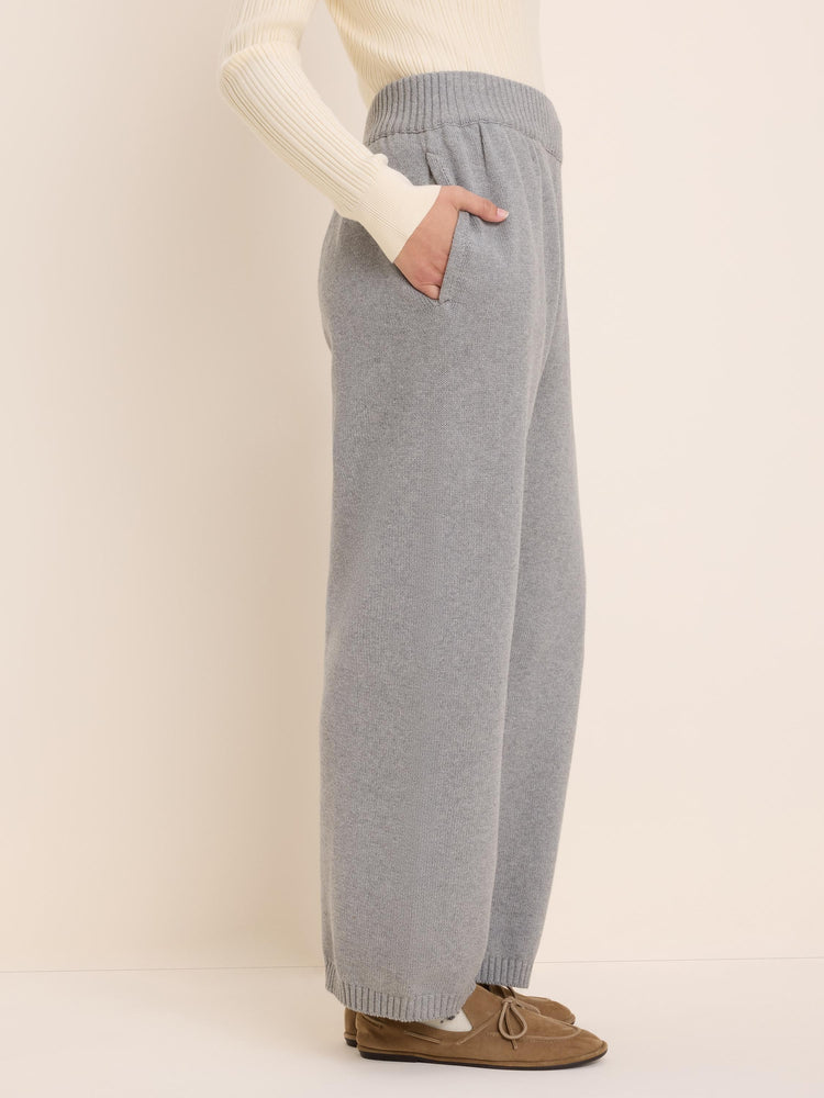Light grey knit sweater pants with a ribbed elastic waist, side pockets, and wide legs with ribbed cuffs.