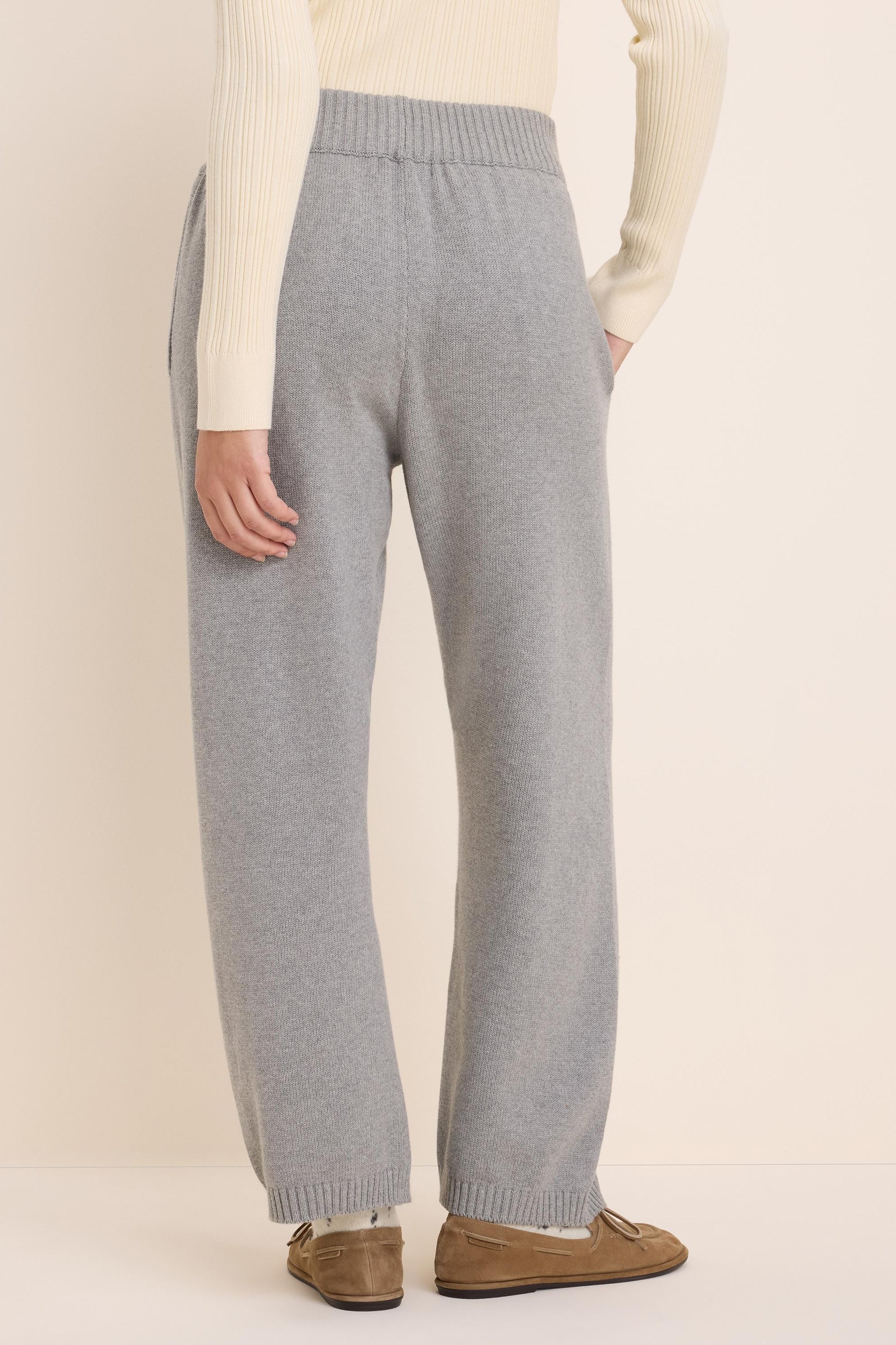 Light grey knit sweater pants with a wide-leg fit and a ribbed elastic waistband, shown from the back.