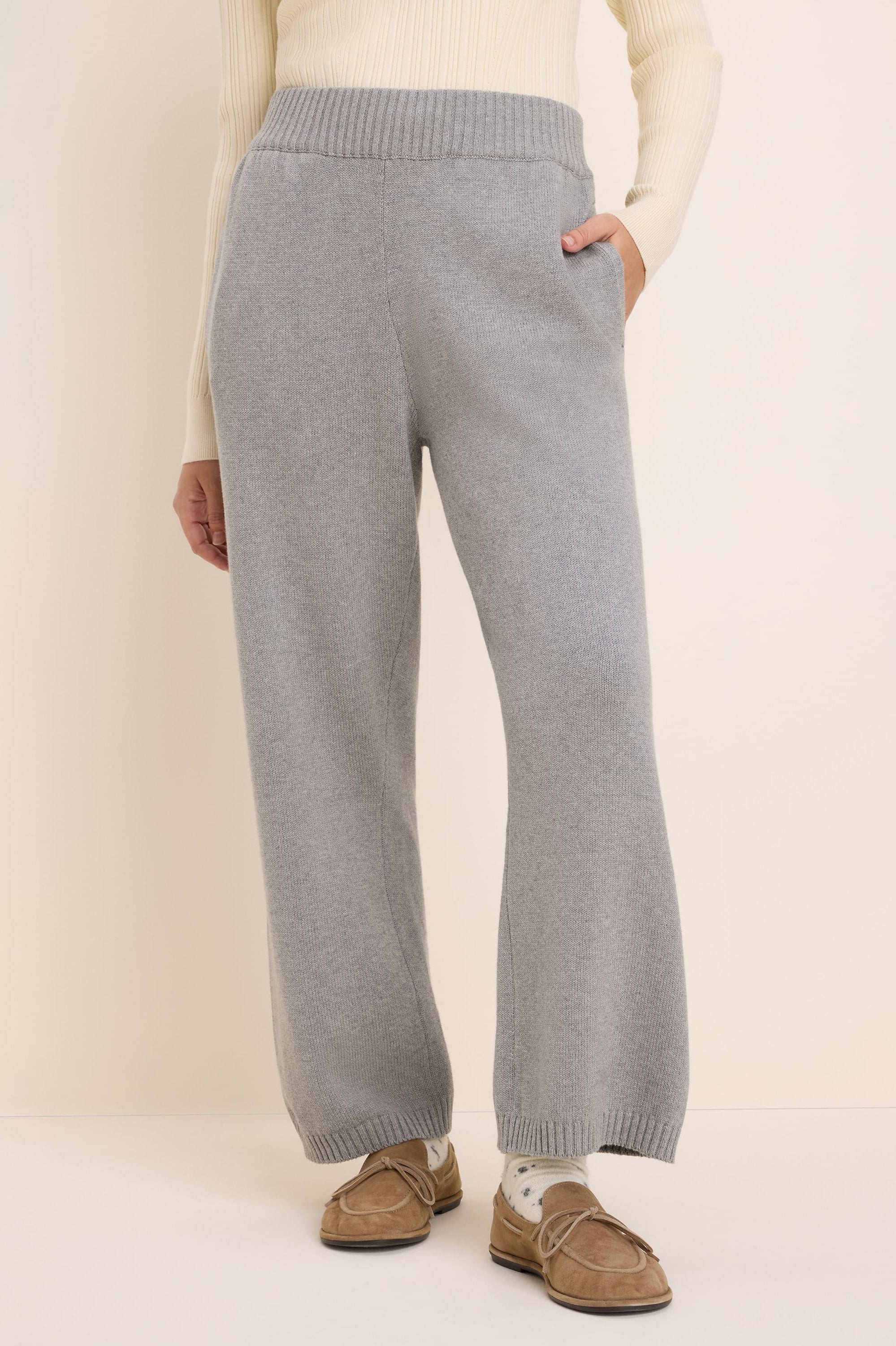 Light grey knit sweater pants with a ribbed waist, side pockets, and wide, relaxed legs.