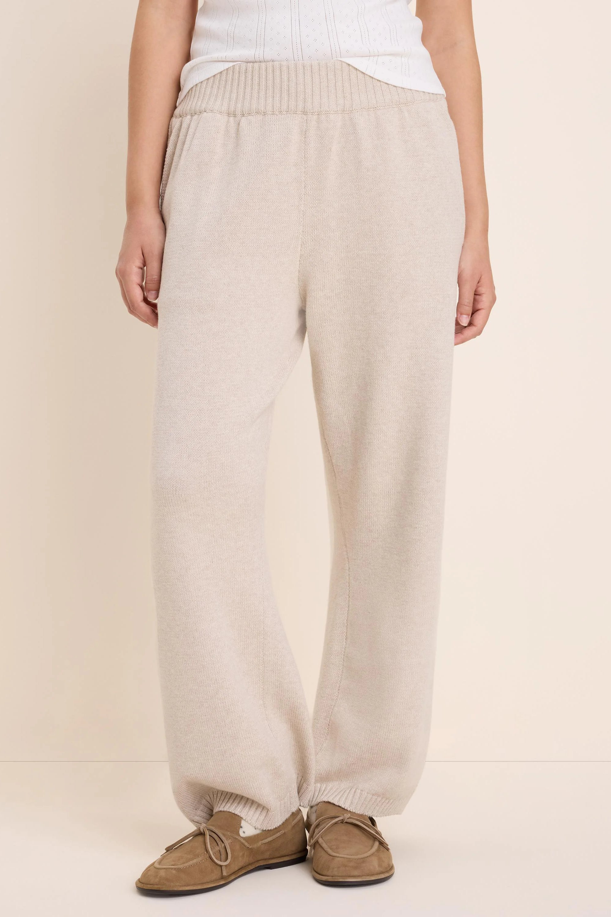 Light beige knit sweater pants with a ribbed waistband and relaxed fit.