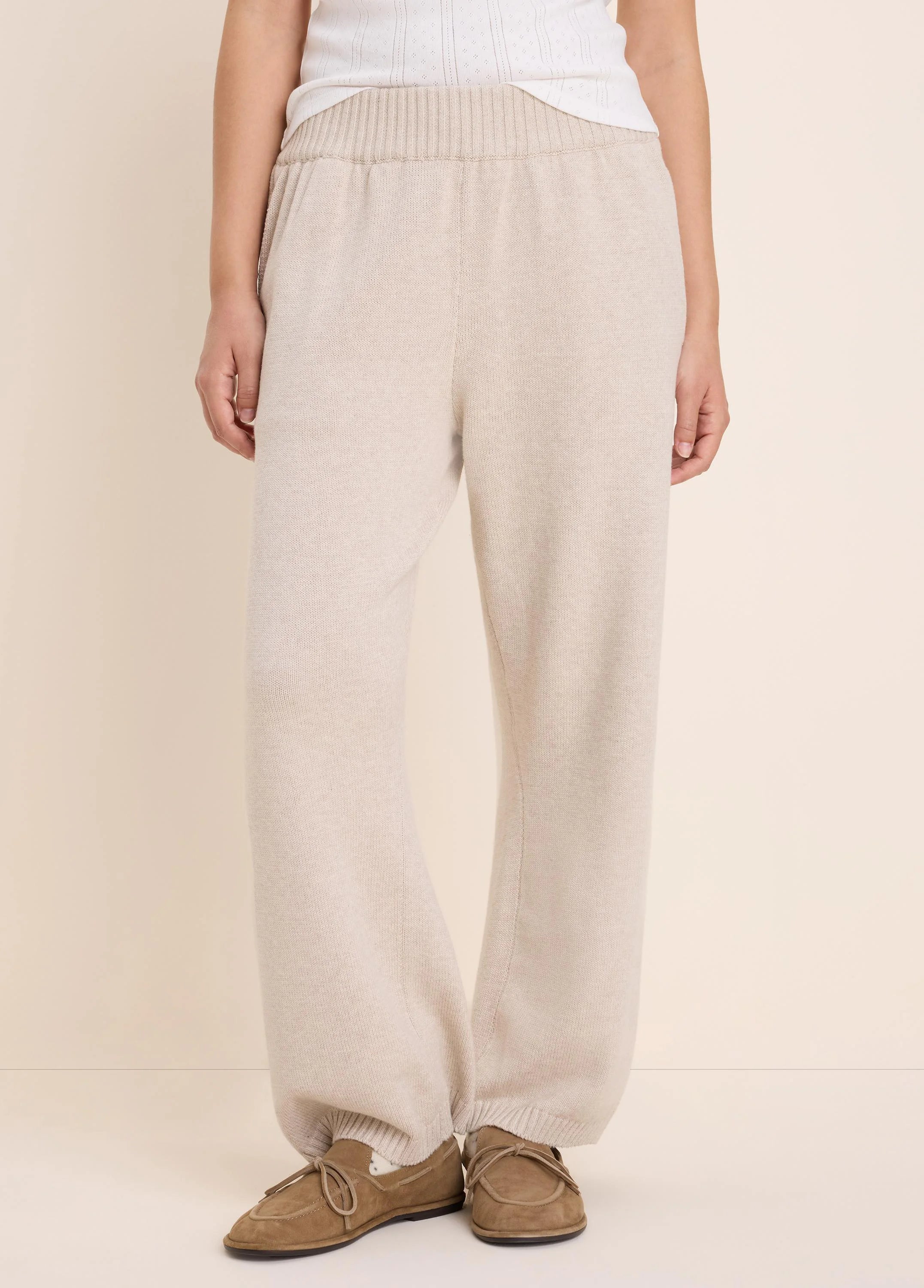 Light beige knit sweater pants with a ribbed waistband and relaxed fit.