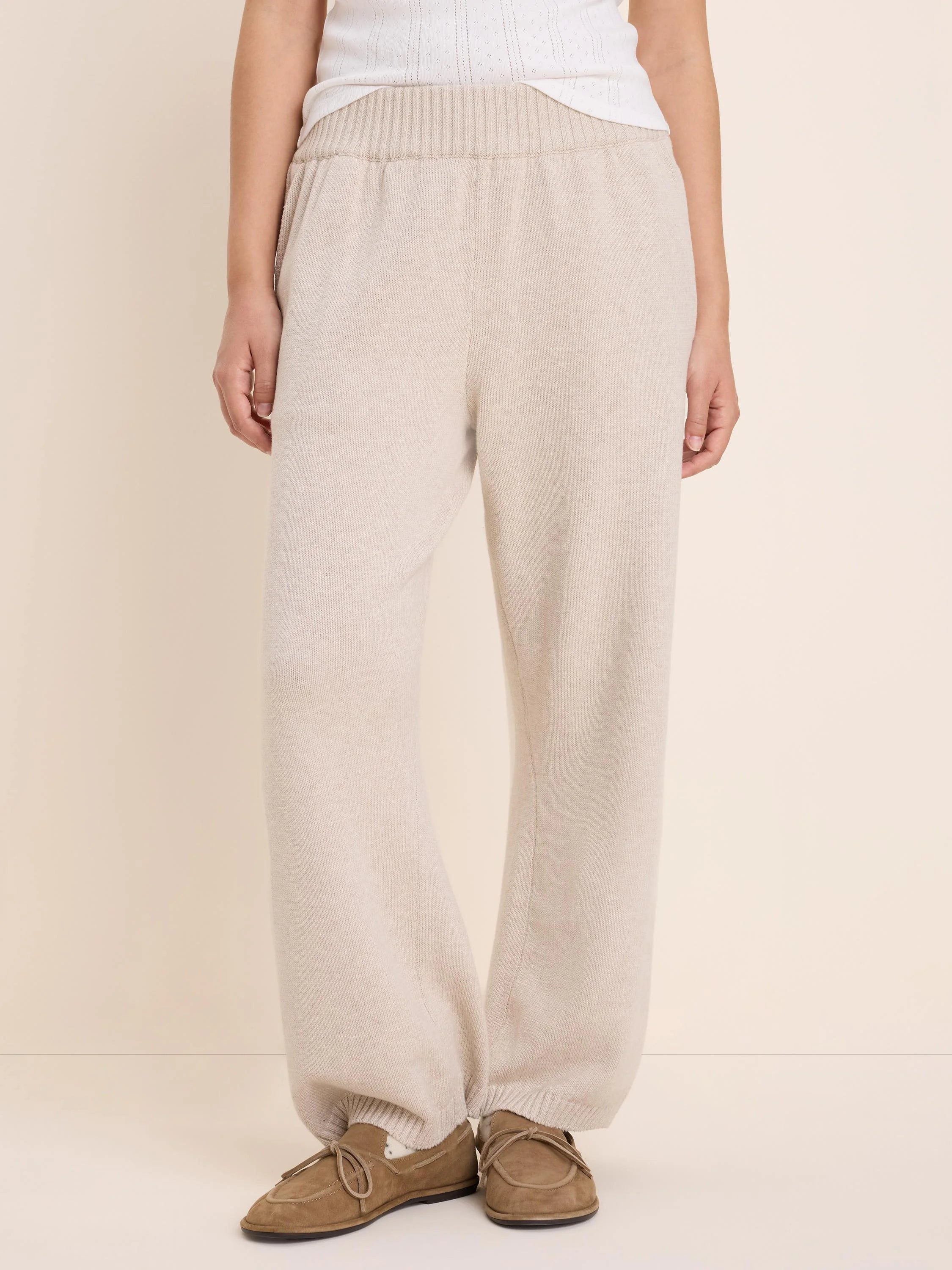 Light beige knit sweater pants with a ribbed waistband and relaxed fit.