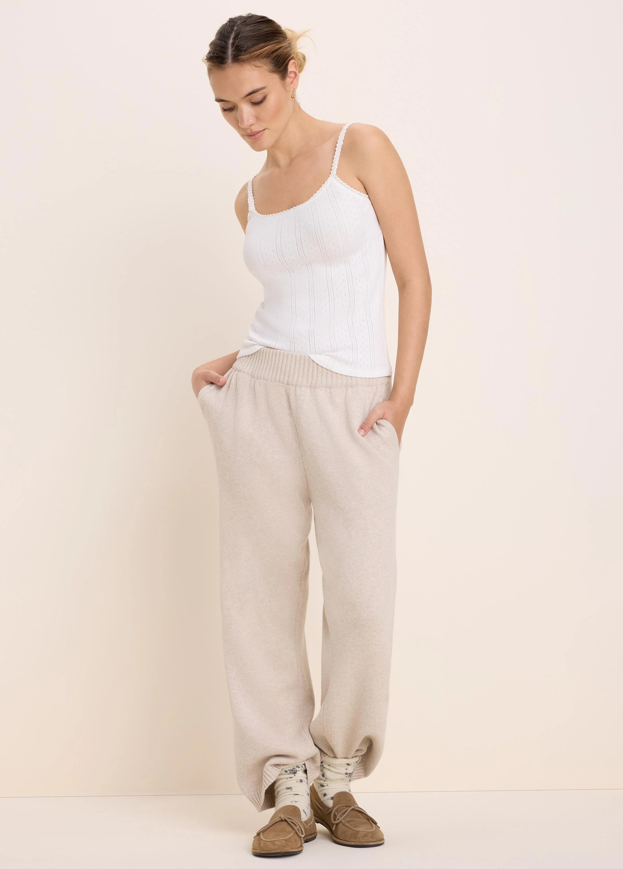 Light beige, relaxed knit sweater pants with a ribbed waist and side pockets.