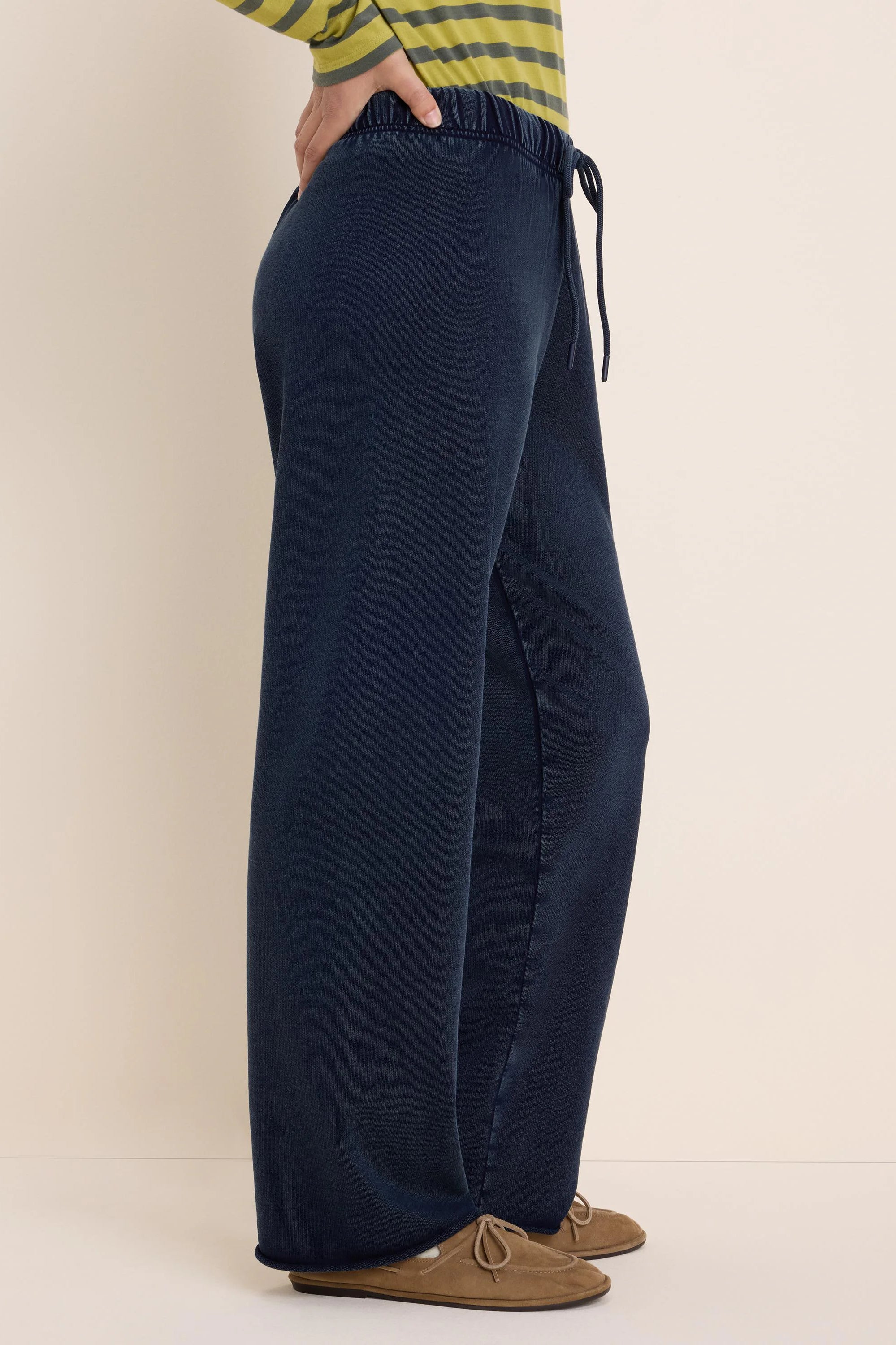 Dark navy wide-leg pants with elastic drawstring waist, showing subtle terry texture. Model shown from side.
