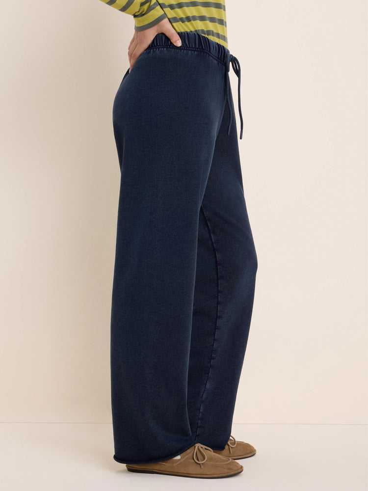 Dark navy wide-leg pants with elastic drawstring waist, showing subtle terry texture. Model shown from side.