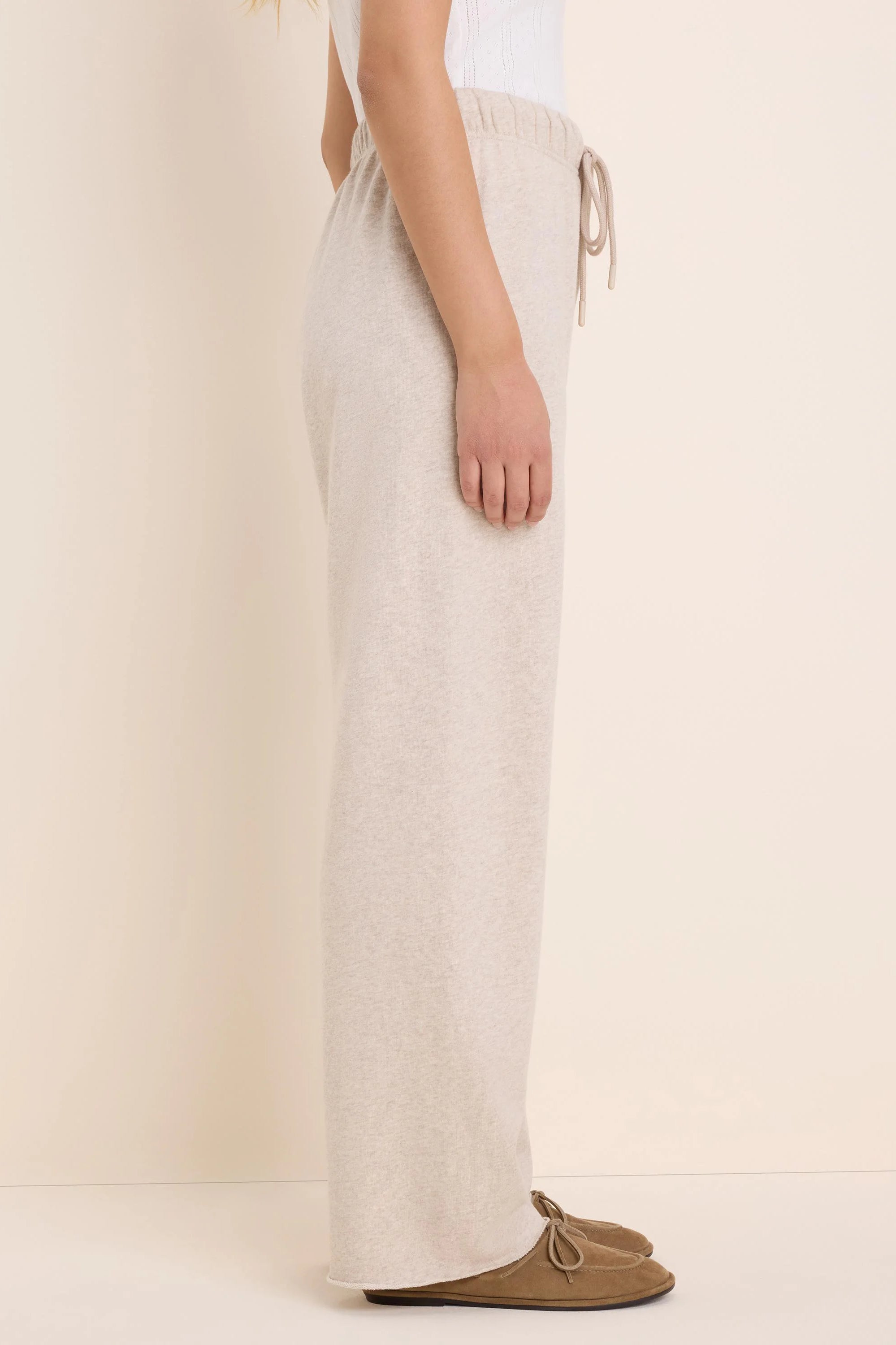 Heathered light beige wide-leg pant with a drawstring elastic waist and raw hem, worn from waist to feet.