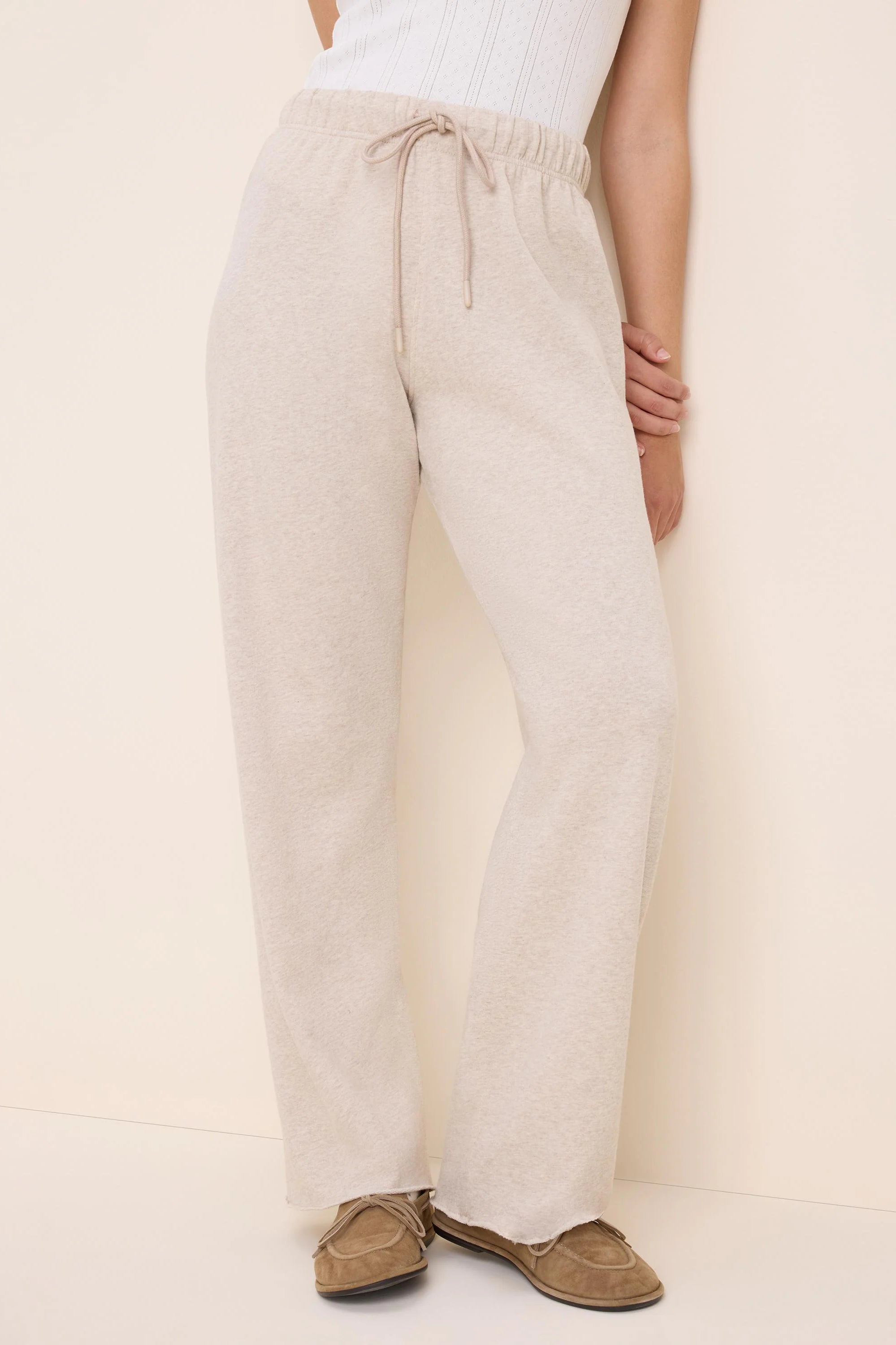 Oatmeal heathered pants with an elastic drawstring waist and wide legs, raw hem.