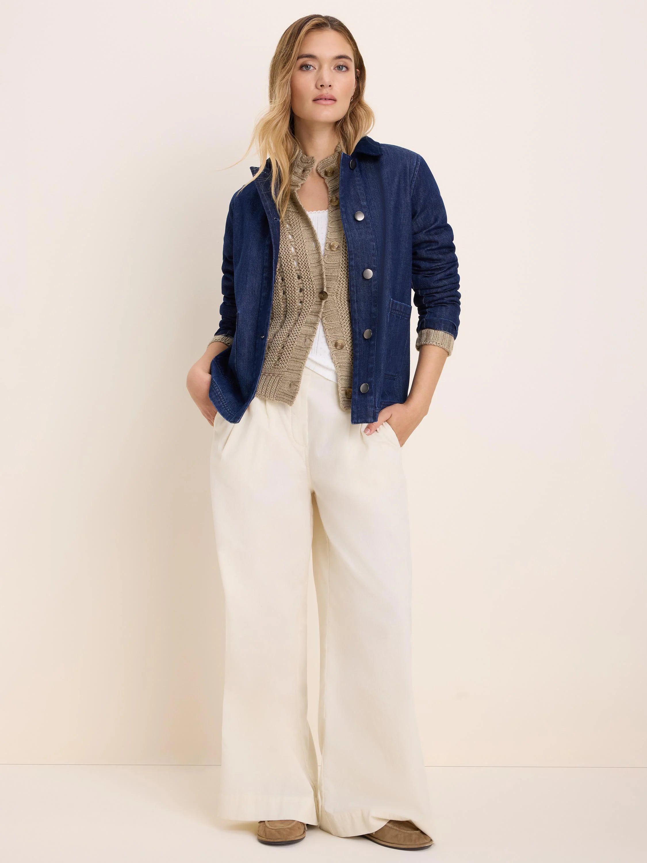 Dark blue denim trucker jacket with silver buttons and chest pockets.