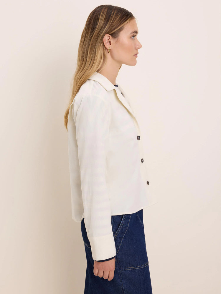 Off-white baby corduroy shirt jacket with a collar, dark buttons, and cuffed long sleeves.