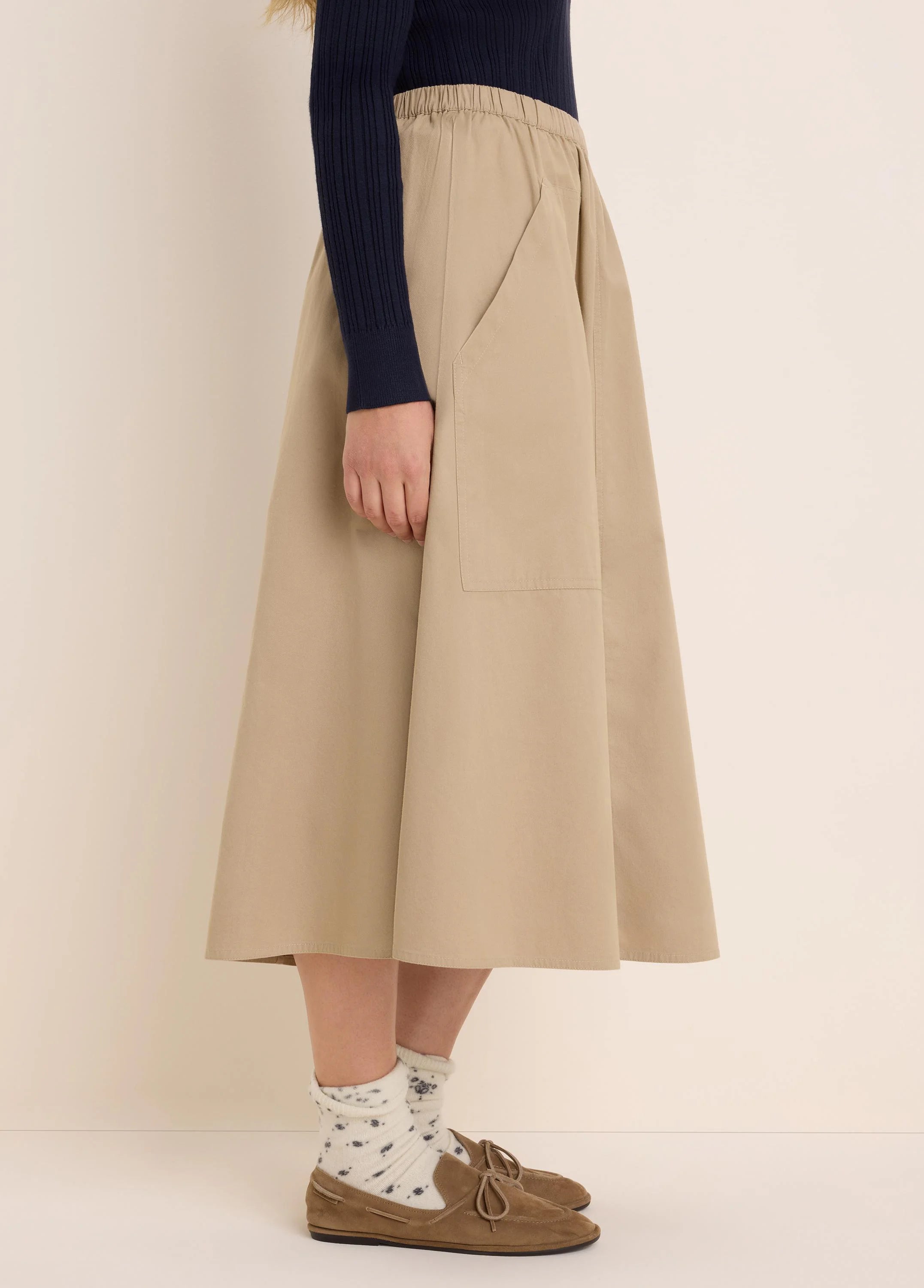 Beige twill cargo skirt. Features an elastic waist, an A-line cut, and a large side patch pocket.