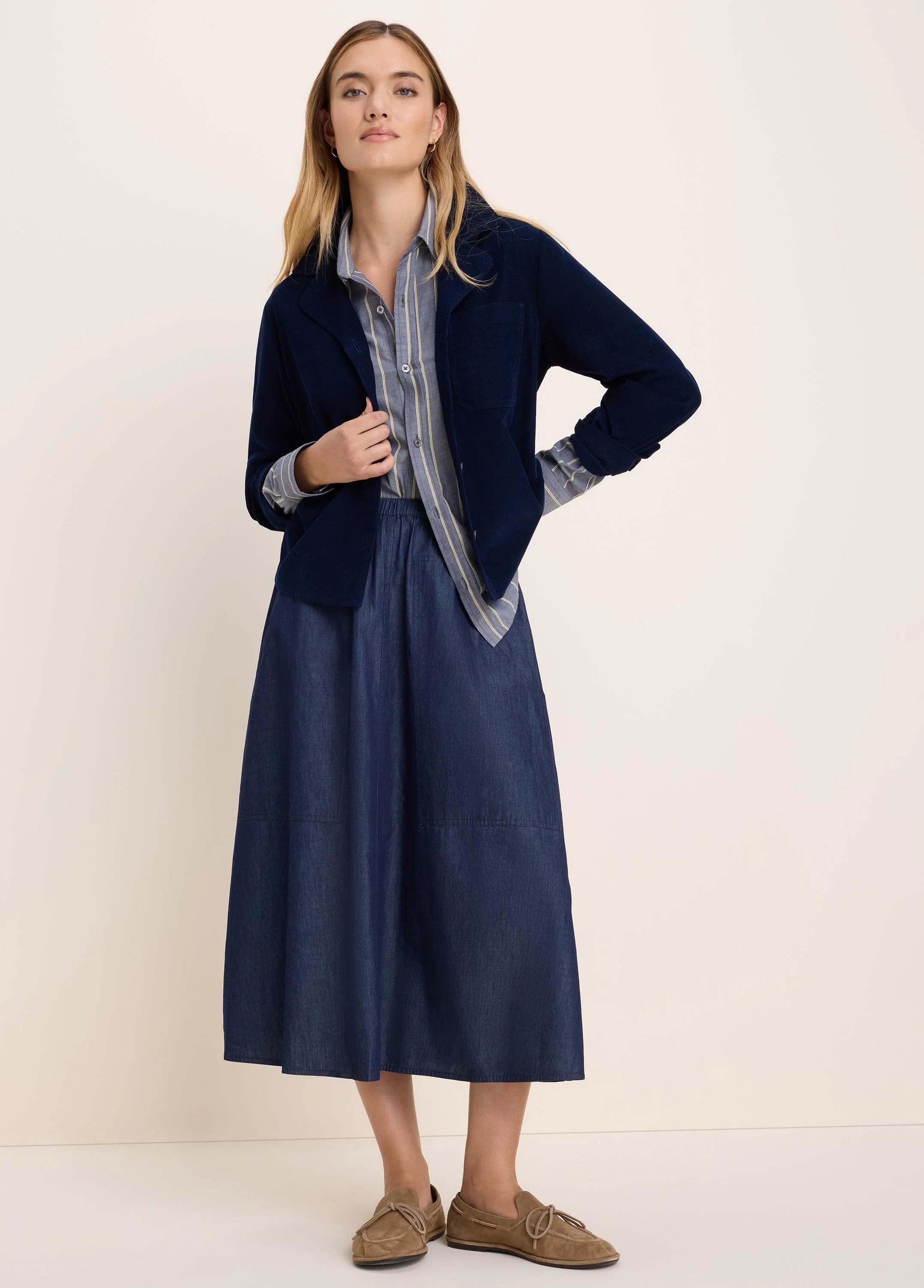 Drapey dark blue denim midi skirt with an elastic waist and large patch pockets.