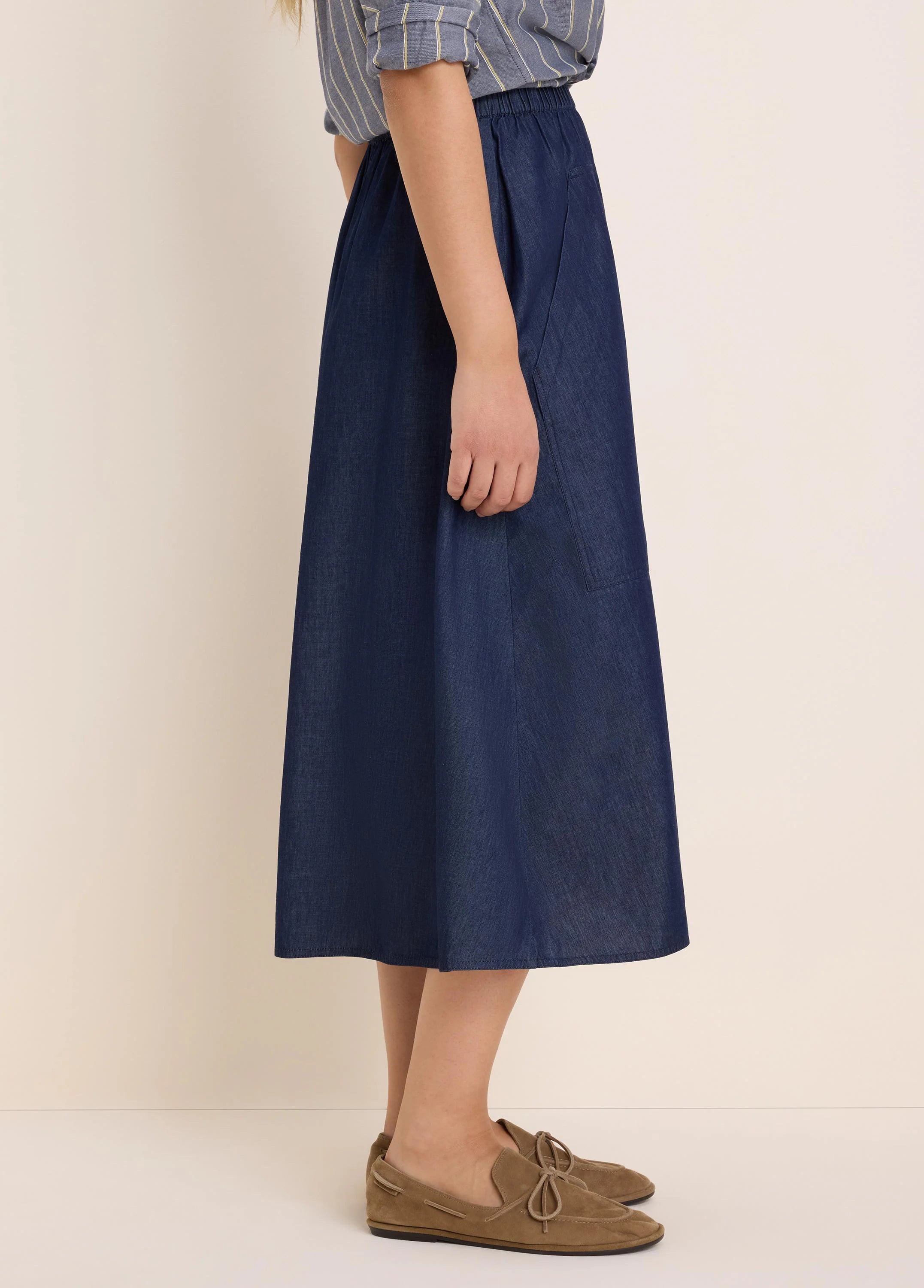 Indigo drapey denim skirt, A-line midi, elastic waist, and a side patch pocket.