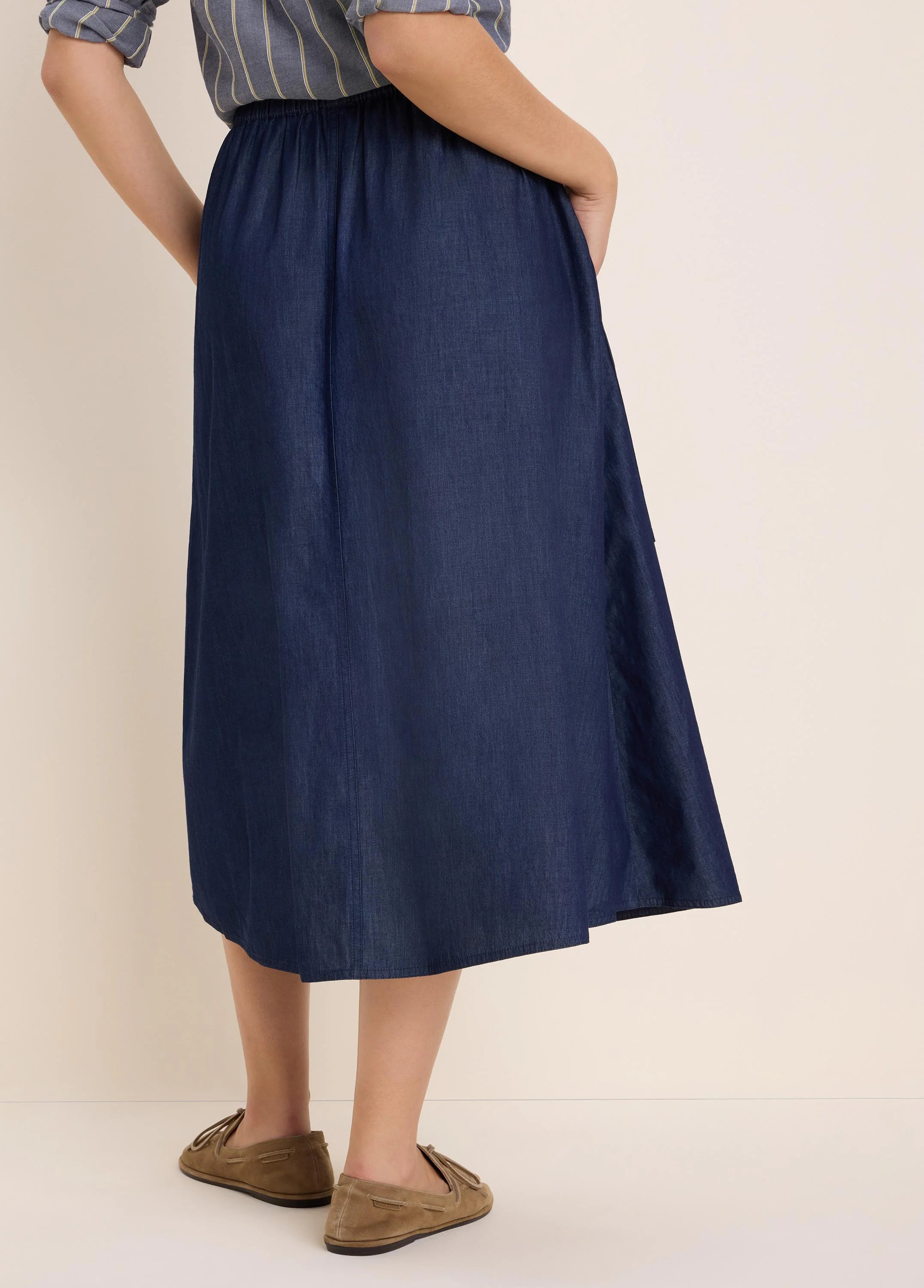 Dark blue drapey denim midi skirt with elastic waist and a flowing A-line cut.