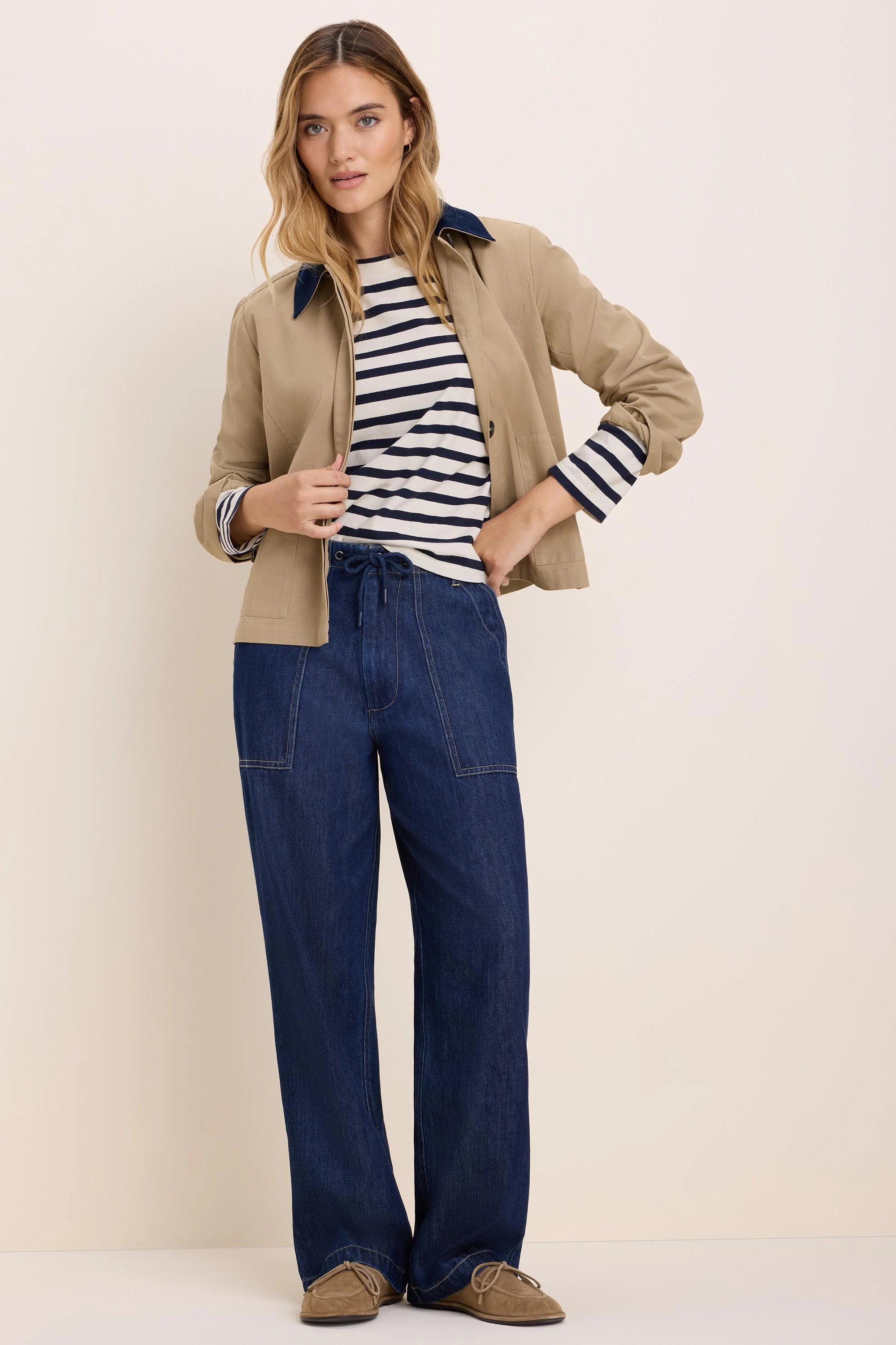 Dark blue wide-leg drawstring denim pants with prominent light brown topstitching and front patch pockets.