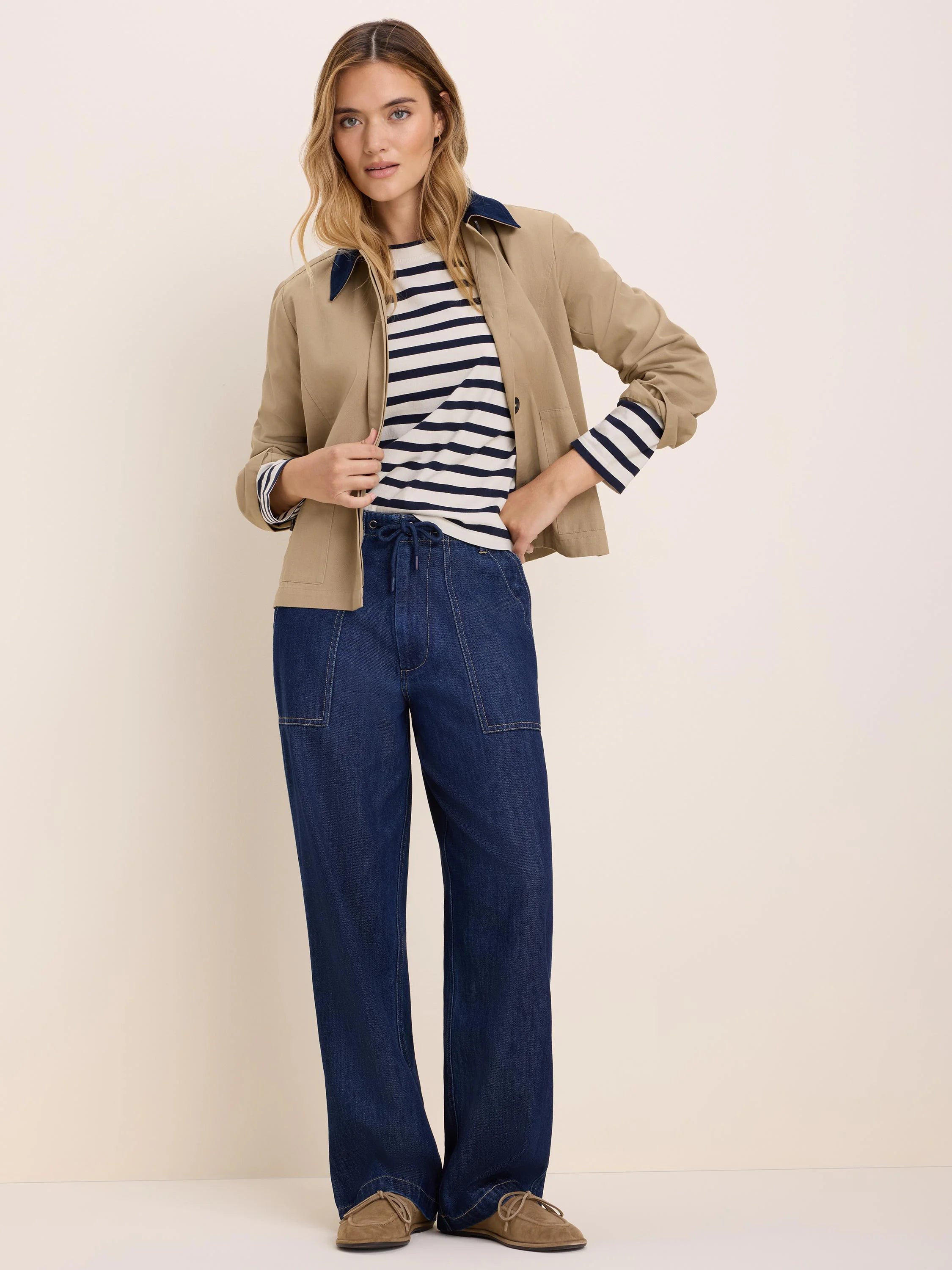 Dark blue wide-leg drawstring denim pants with prominent light brown topstitching and front patch pockets.