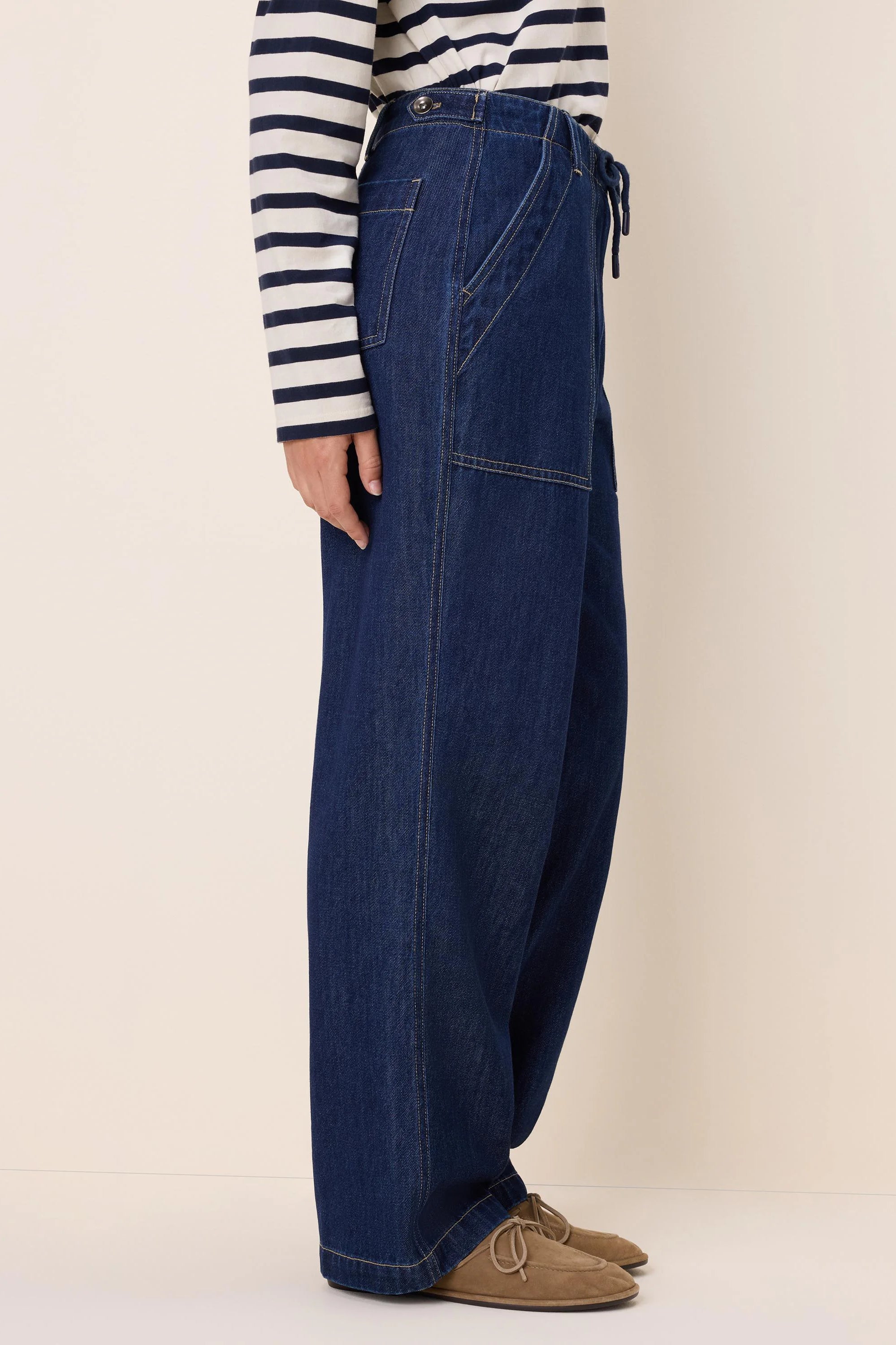 Dark indigo wide-leg denim pants with a drawstring waist, button closure, and light contrast stitching.