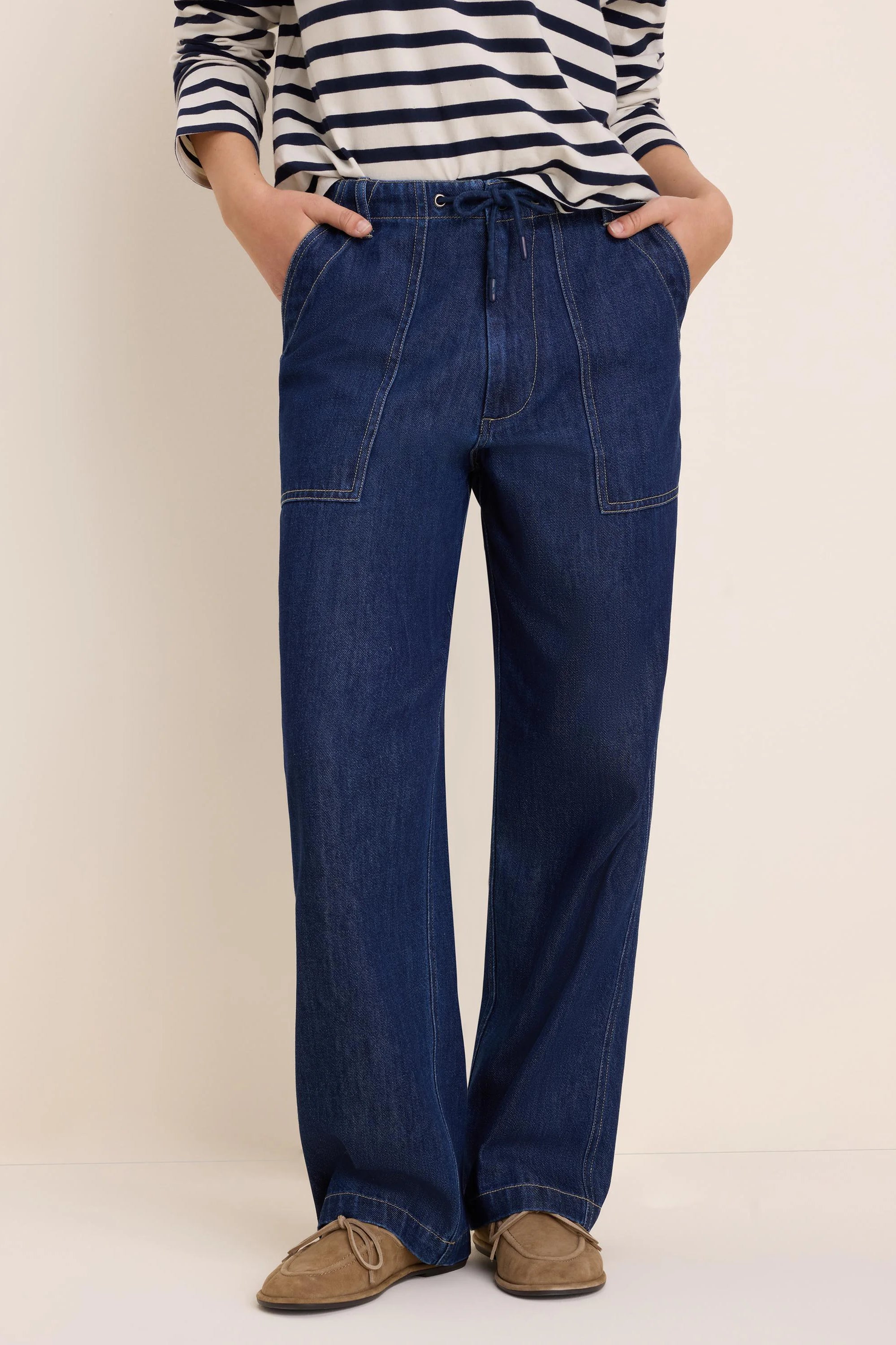 Dark blue, wide-leg denim pants with drawstring waist, large front patch pockets, and contrasting light stitching.