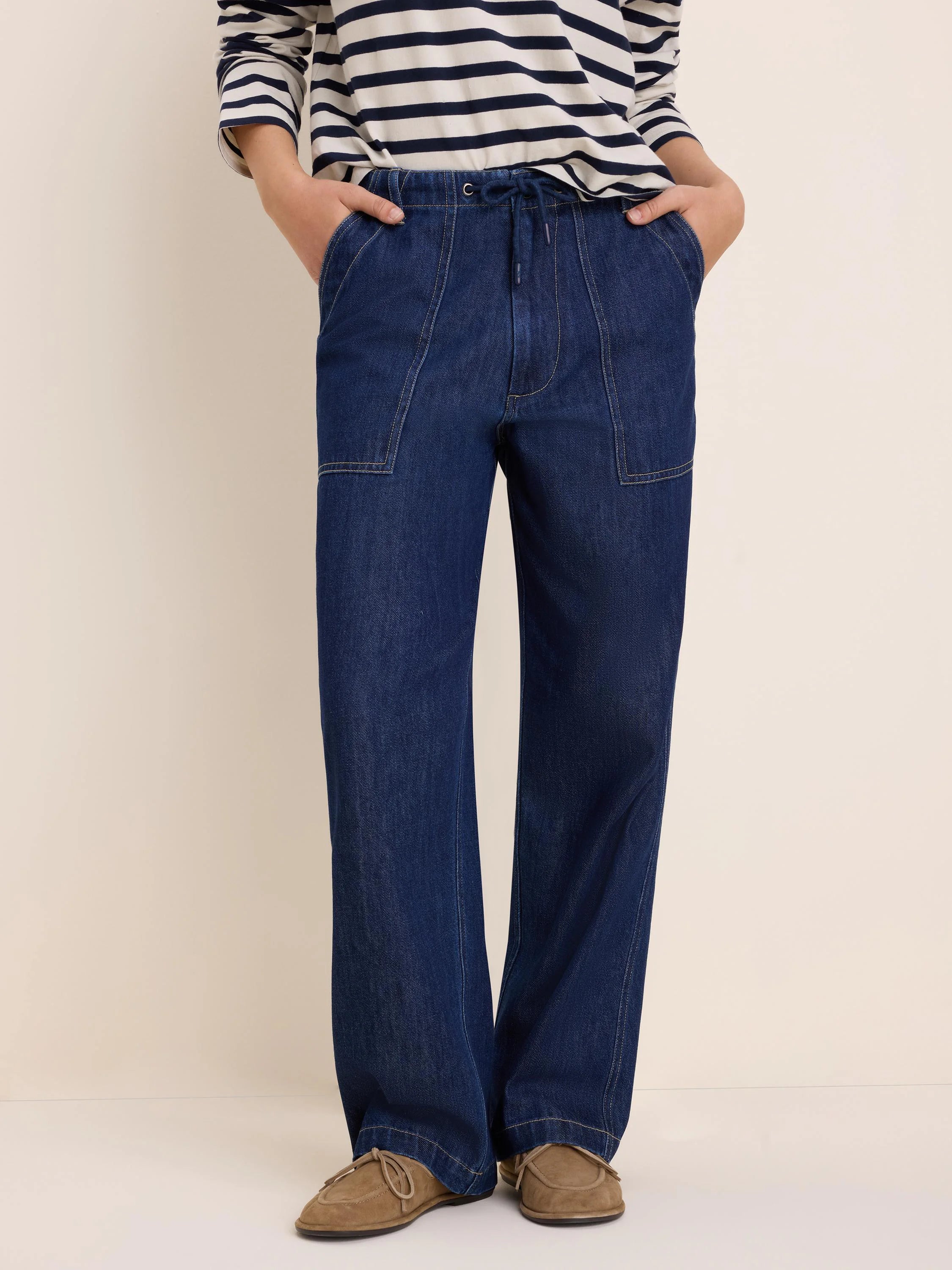Dark blue, wide-leg denim pants with drawstring waist, large front patch pockets, and contrasting light stitching.