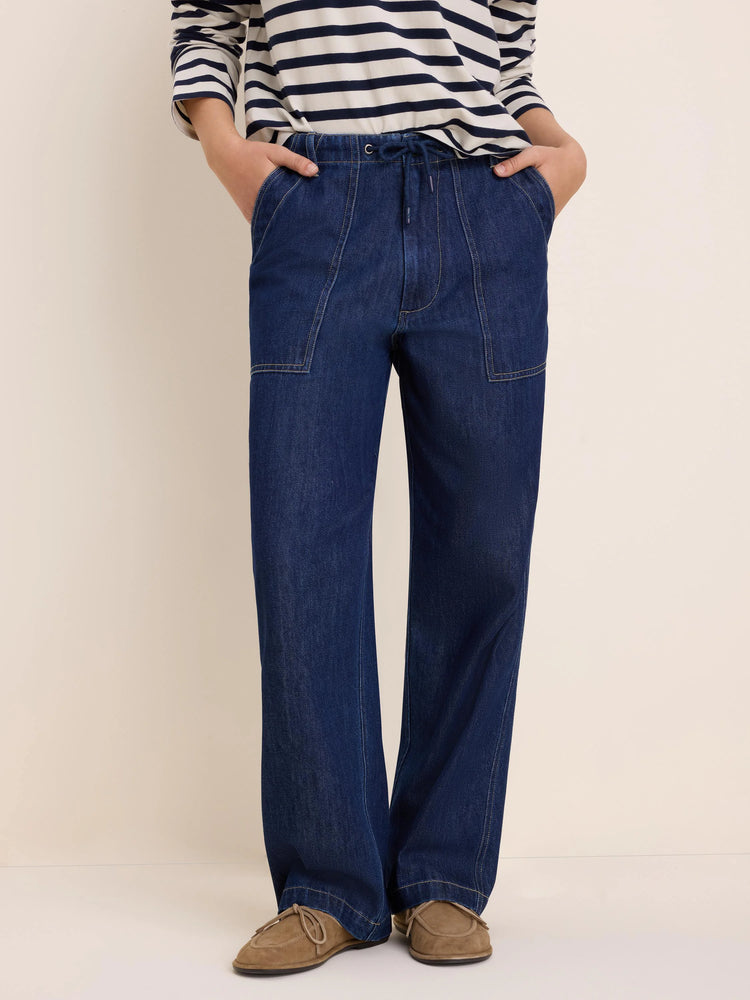 Dark blue, wide-leg denim pants with drawstring waist, large front patch pockets, and contrasting light stitching.
