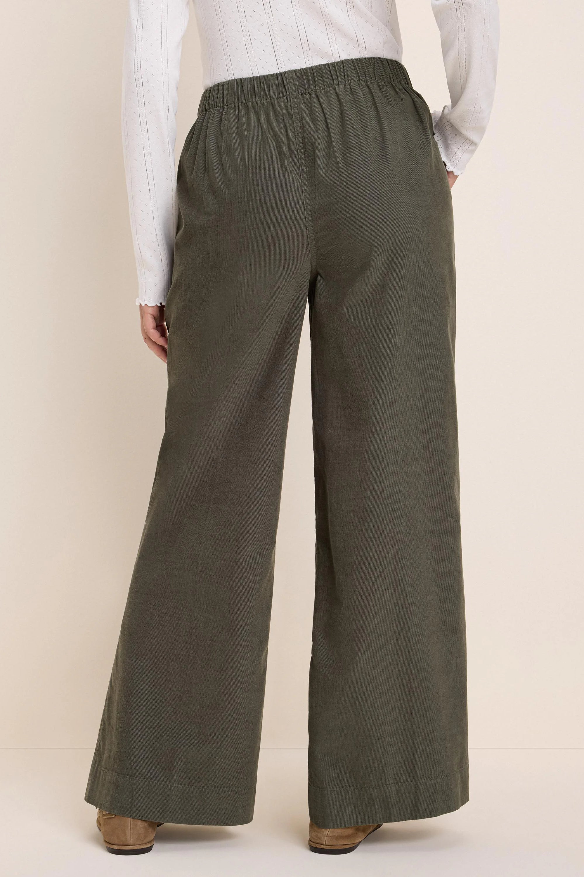Dark olive green baby cord wide-leg pants with an elasticated waist, shown from the back.