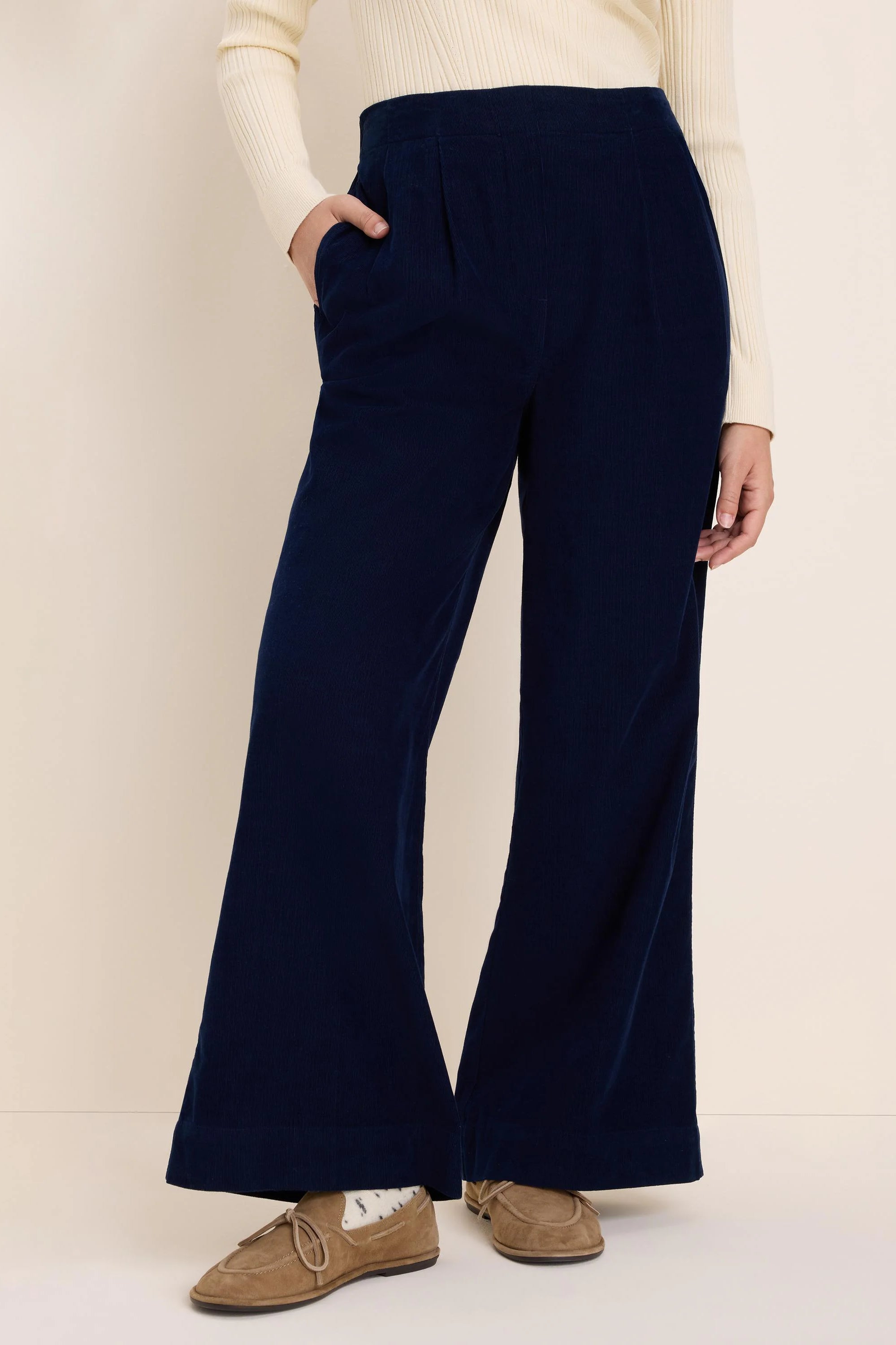 Navy corduroy pants, high-waisted, wide-leg with front pleats and side pockets.