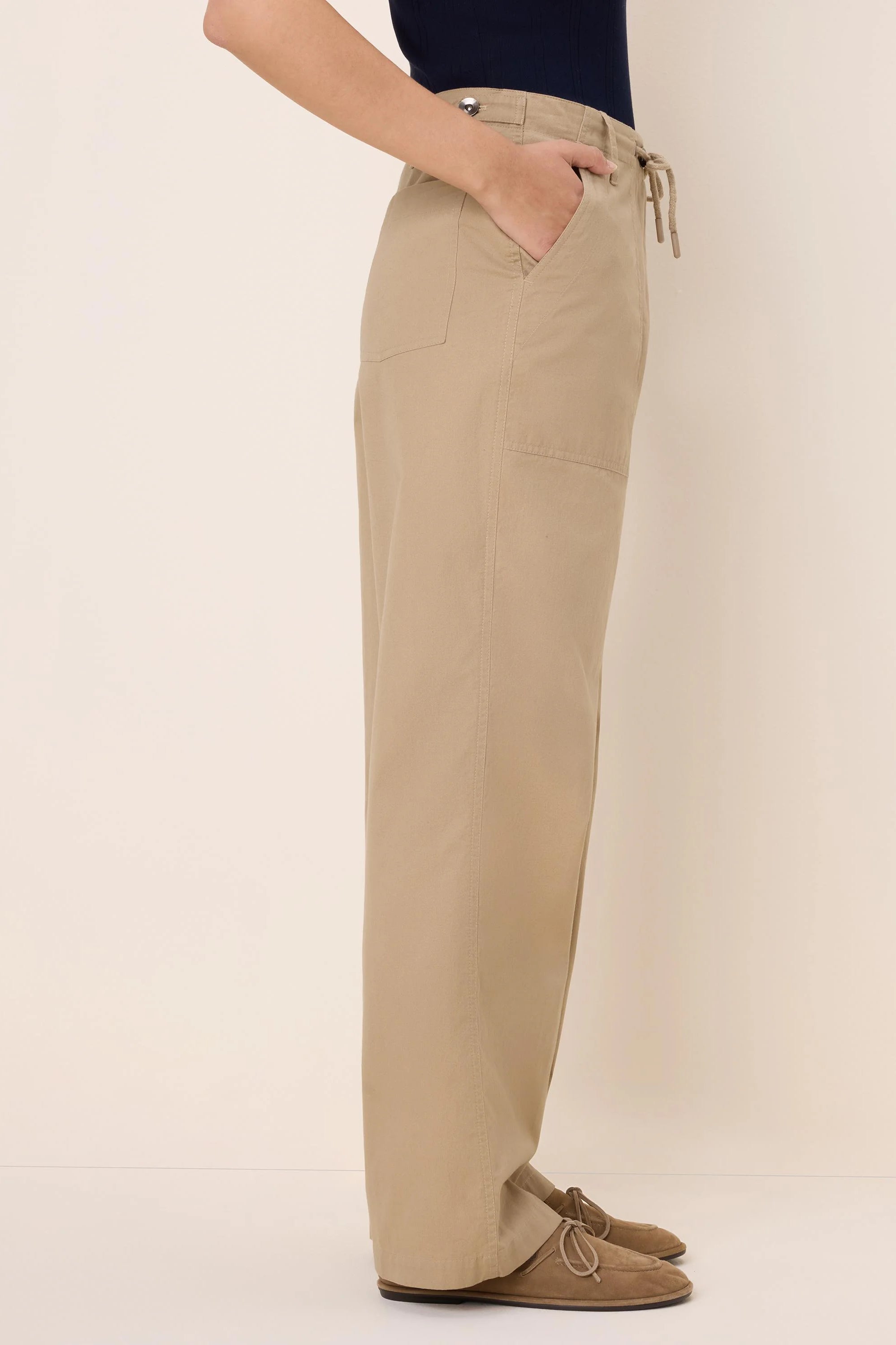 Khaki drawstring twill pants with a wide leg. Features a front slash pocket, side patch pocket, and a button closure.