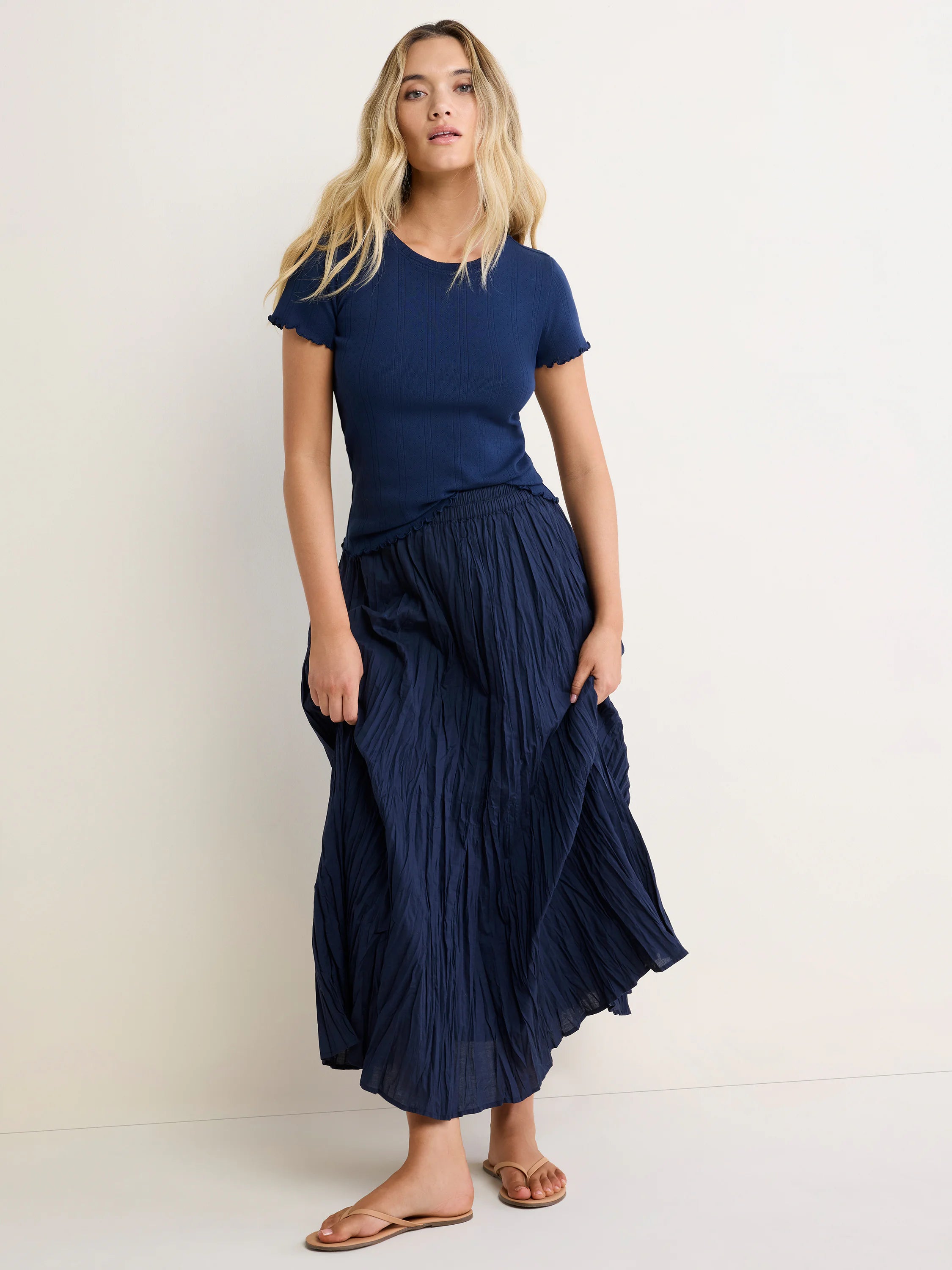 Navy blue pointelle rib tee with short sleeves, ruffled edges, and a crew neck, worn by a model.