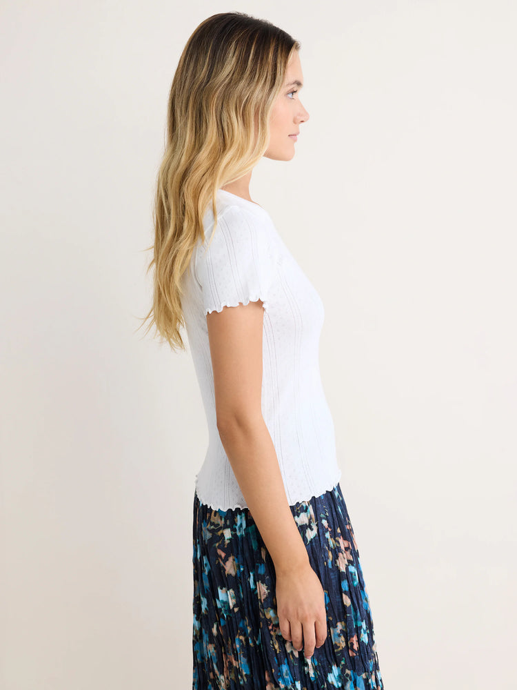White pointelle rib knit tee with ruffled short sleeves and hem.