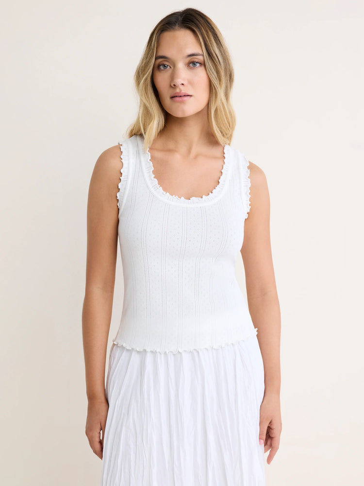 White pointelle rib tank with a subtle dot pattern and ruffled trim along the neckline, armholes, and bottom hem.