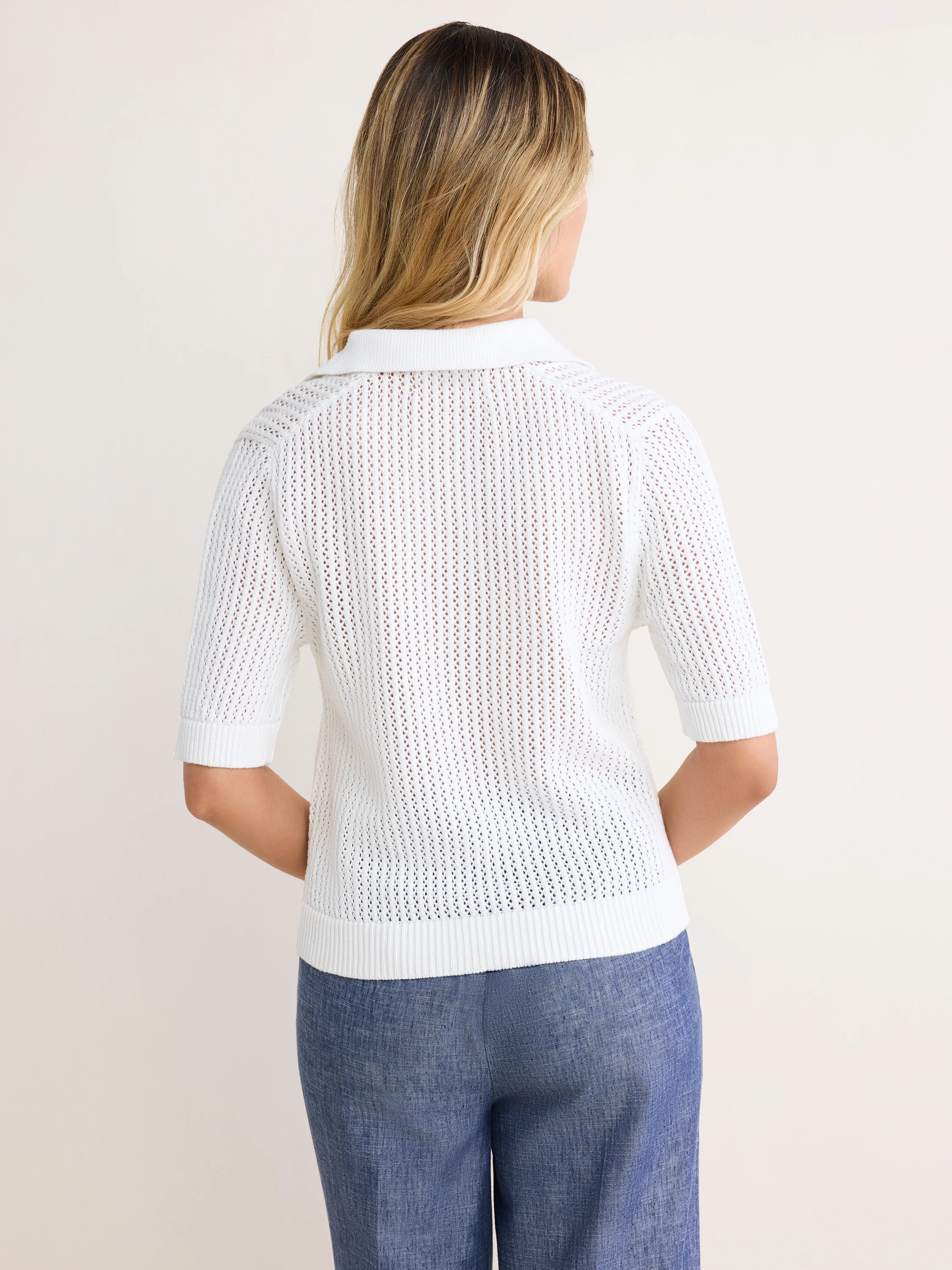 White mesh polo sweater, back view. Short sleeves, polo collar, ribbed cuffs and hem.