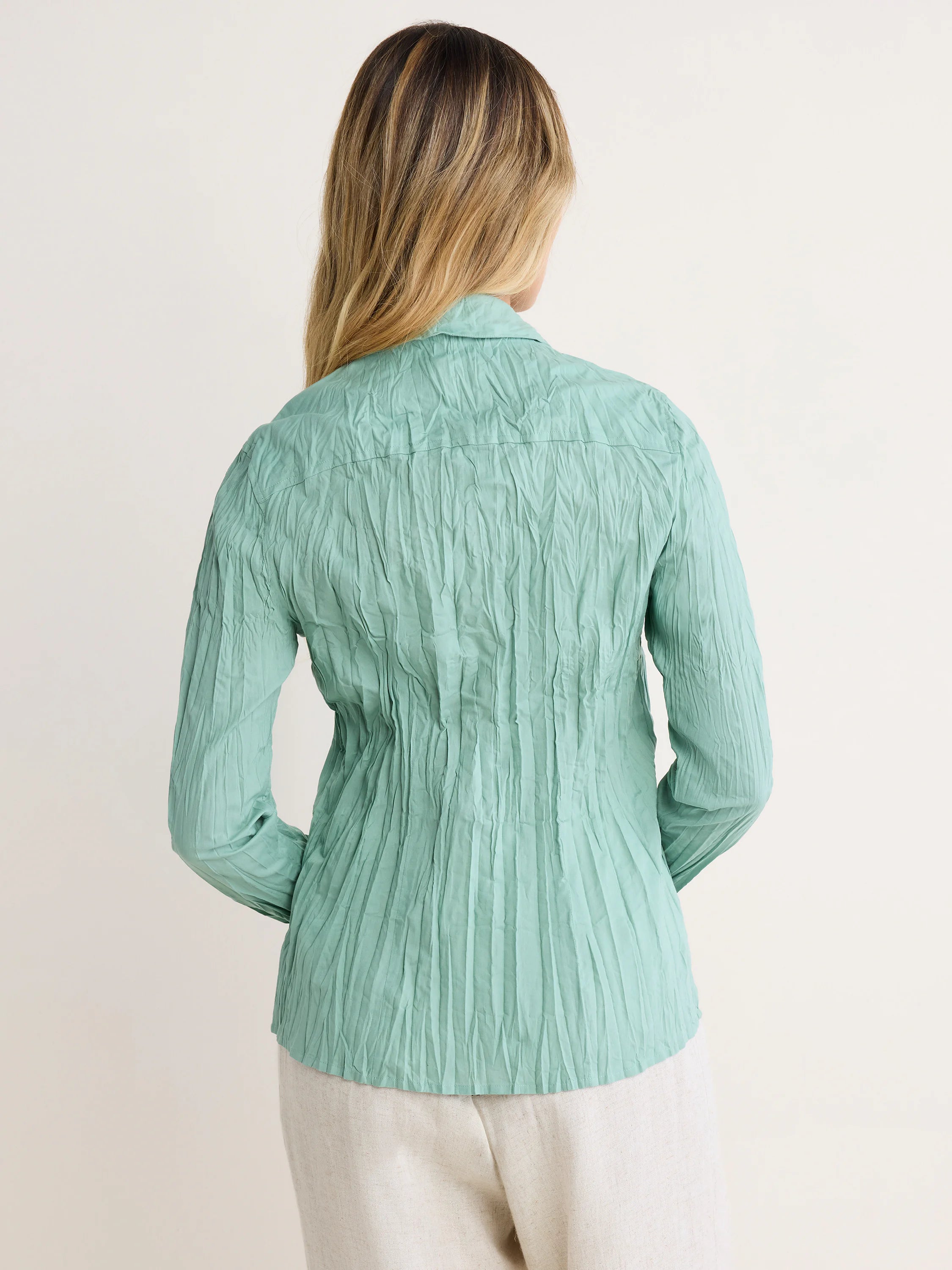 Back view: Mint green, long-sleeved, collared shirt with a heavily crinkled texture.