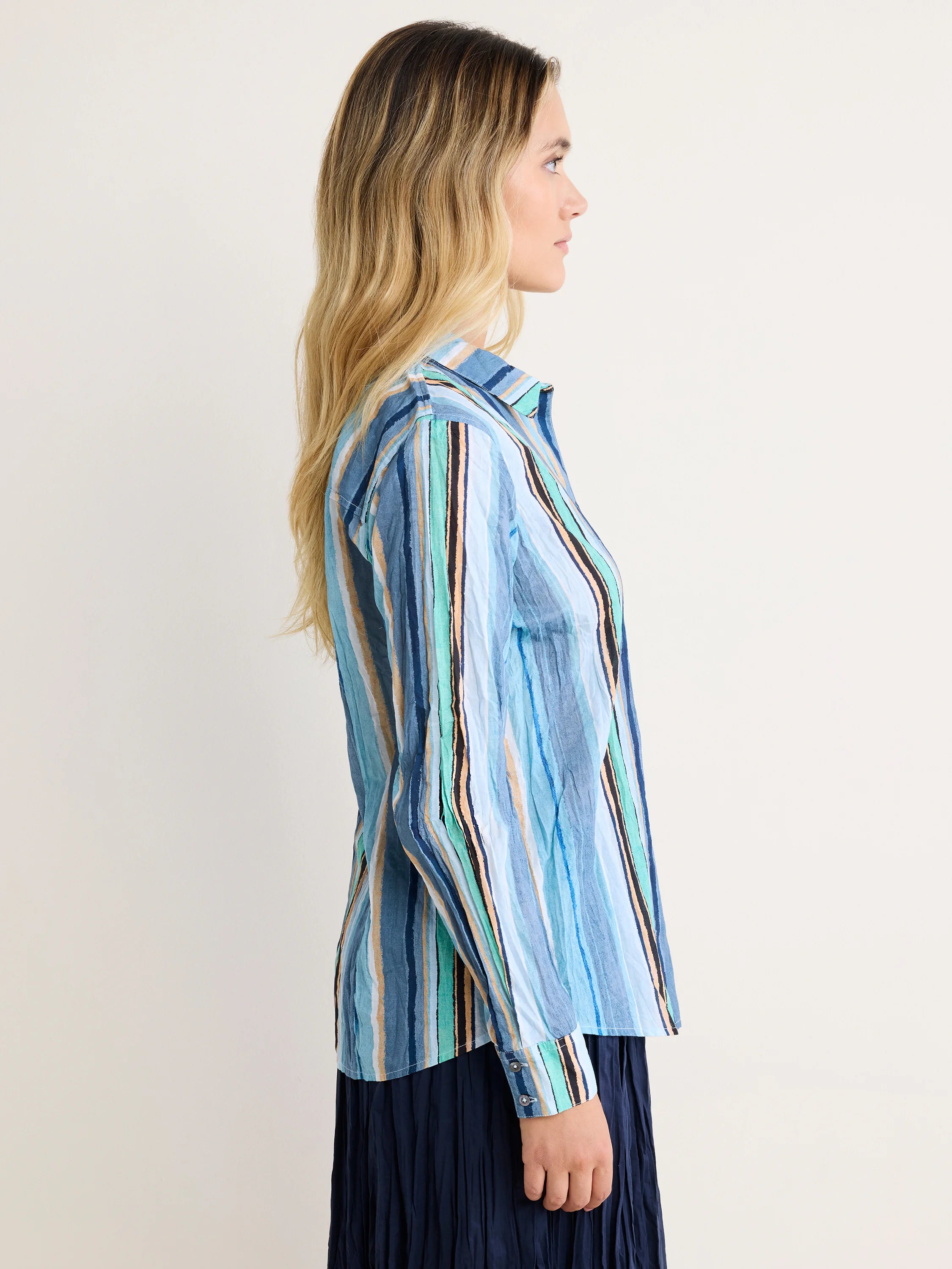Long-sleeved, crinkled cotton shirt with vertical stripes in shades of blue, teal, peach, and black.