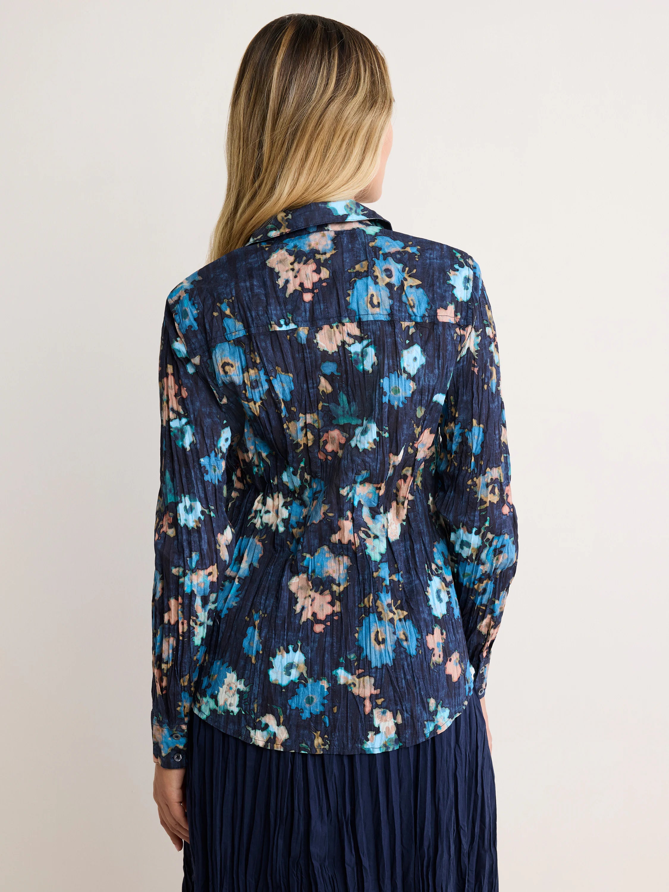 Dark blue crinkled floral shirt with blue, pink, and gold flowers, viewed from the back.