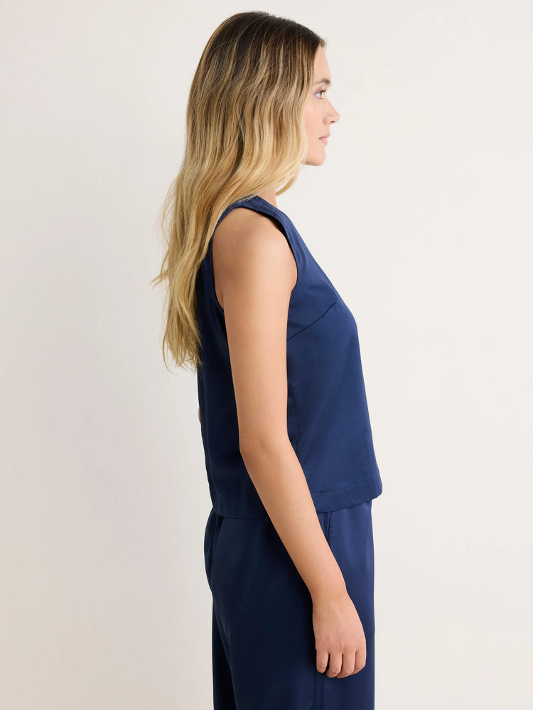 Navy blue Stevie Tank on model in profile. Sleeveless, relaxed fit, smooth fabric.