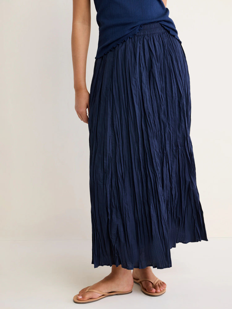 Navy blue cotton crinkle skirt with a distinct textured, wrinkled look and elastic waist. Skirt is full-length.