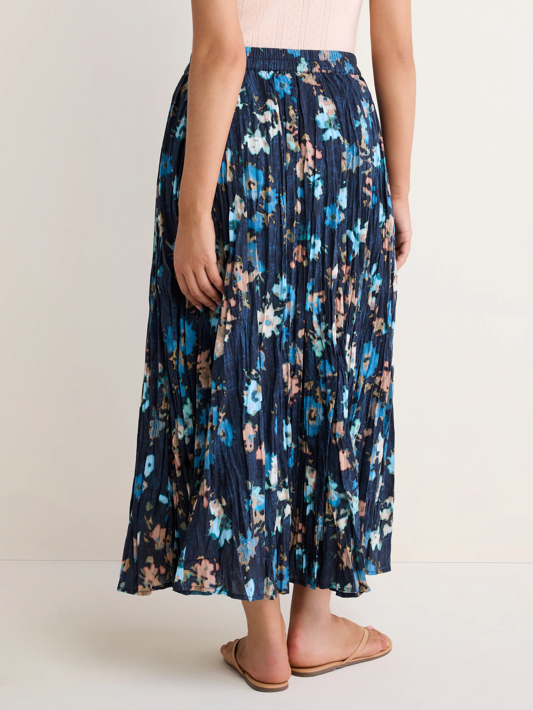 Dark blue crinkle maxi skirt with light blue and peach floral print and elastic waist.