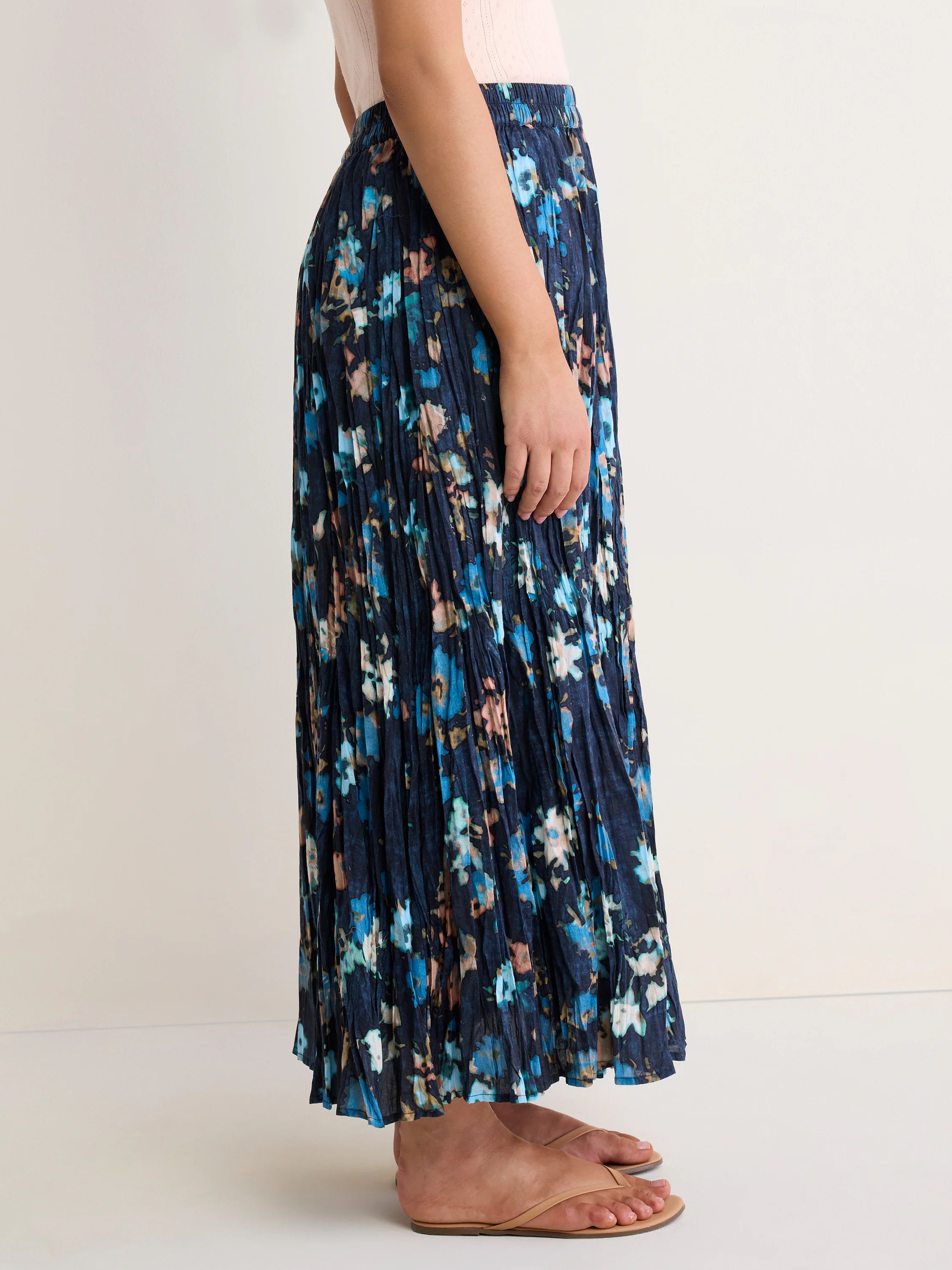 Dark blue crinkle skirt with blue, peach, & tan floral print. Elasticated waist, long length.
