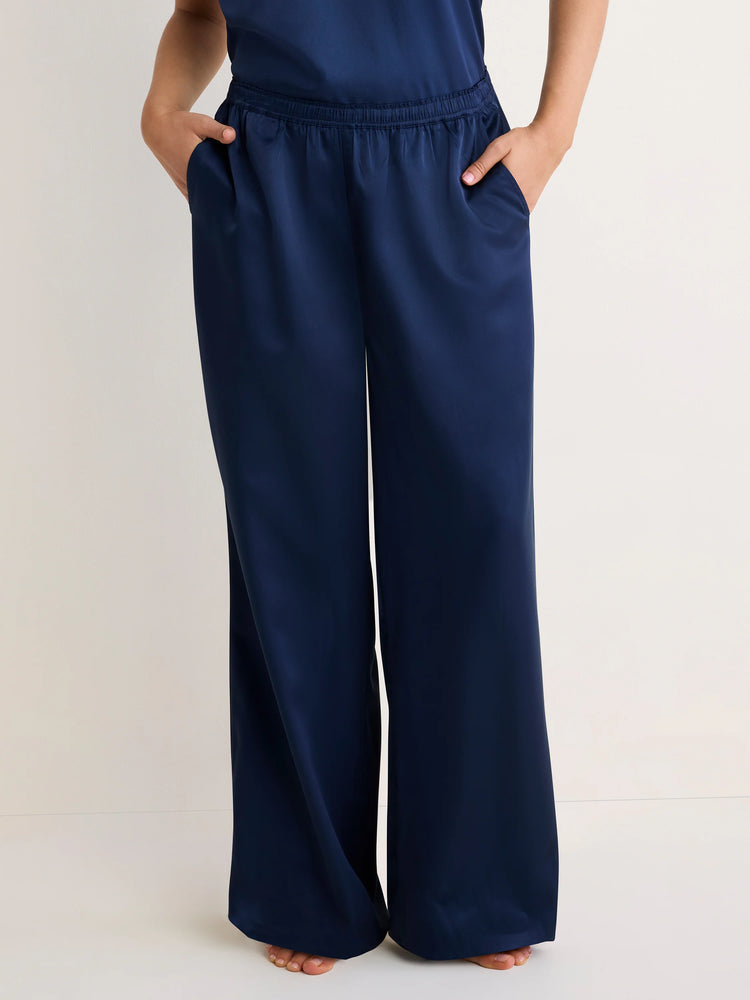 Navy satin wide-leg pants with an elastic waist and side pockets, shown on a model.