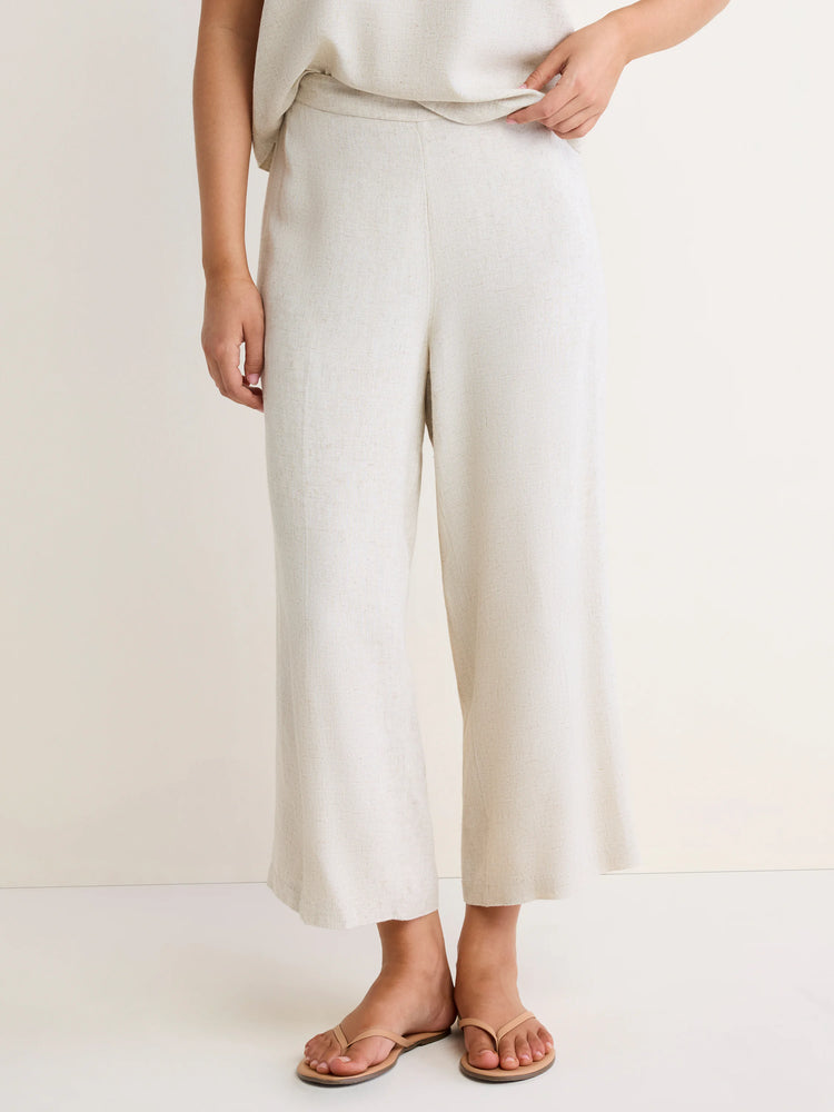 Light beige linen blend pants with a visible texture, featuring a wide, cropped leg, worn by a standing person.
