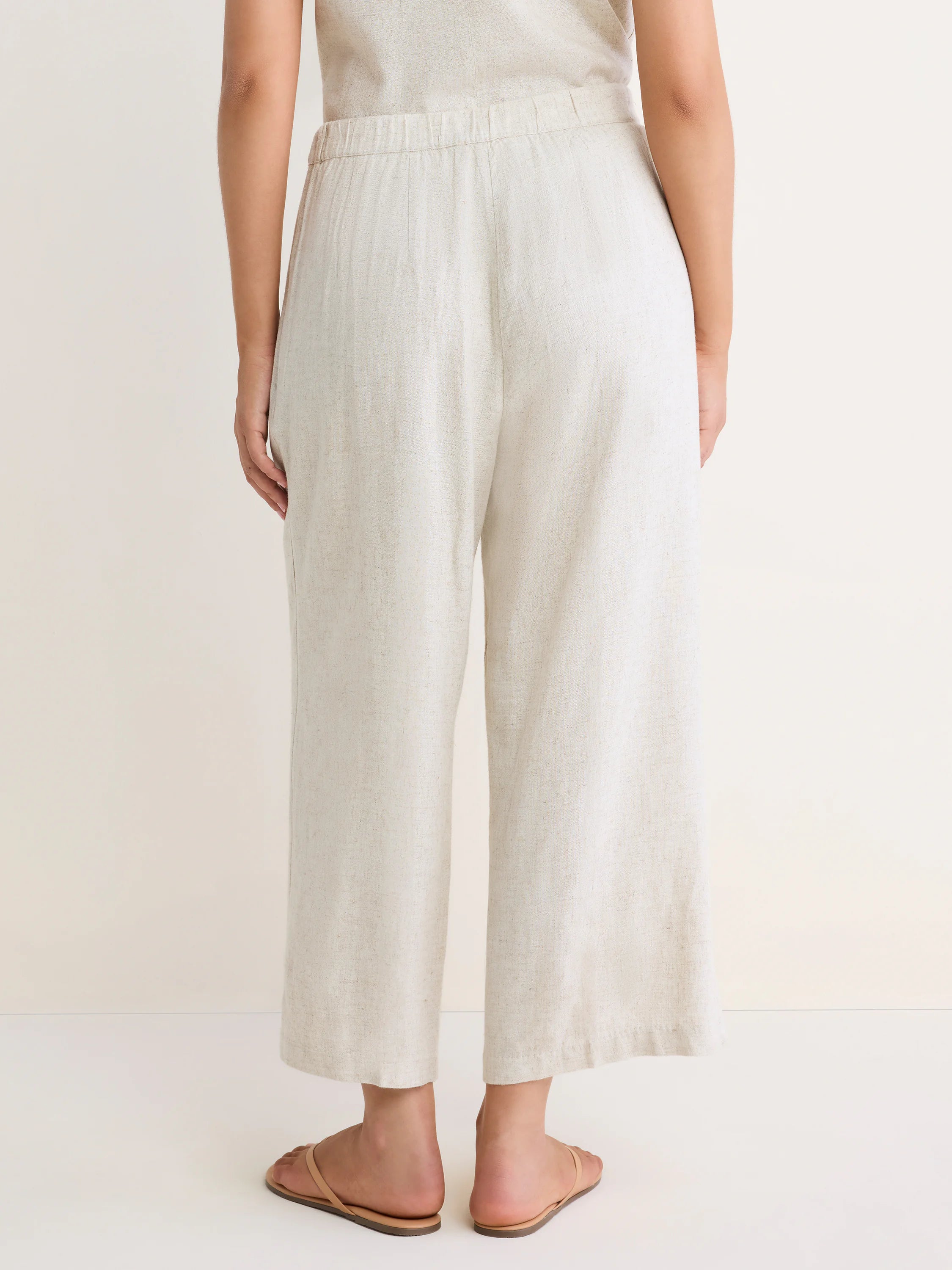 Oatmeal textured wide-leg cropped pants with an elastic waistband, back view.