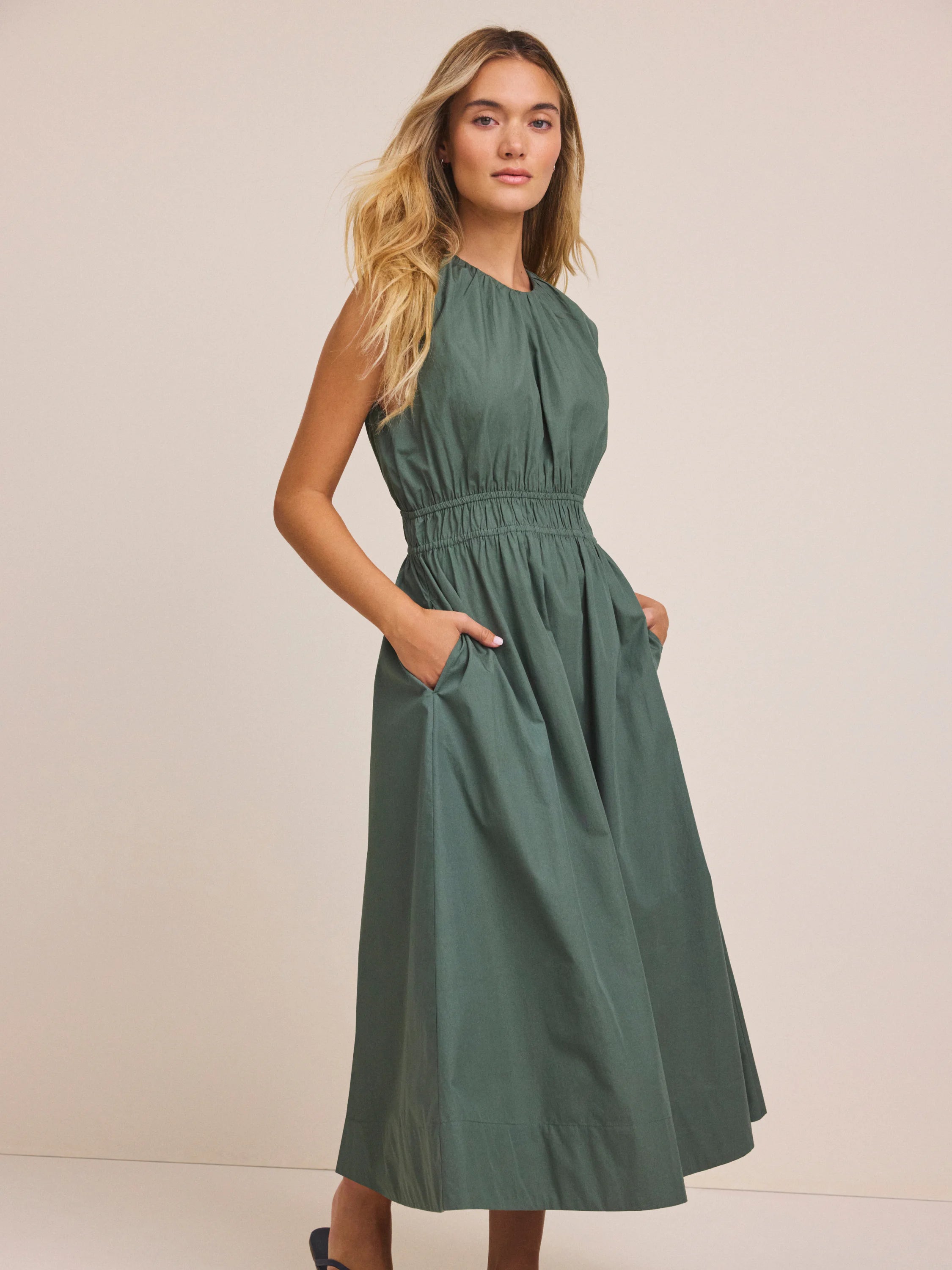 Poplin Dakota Dress: Dark green, sleeveless, gathered top, smocked elastic waist, A-line midi skirt, side pockets.