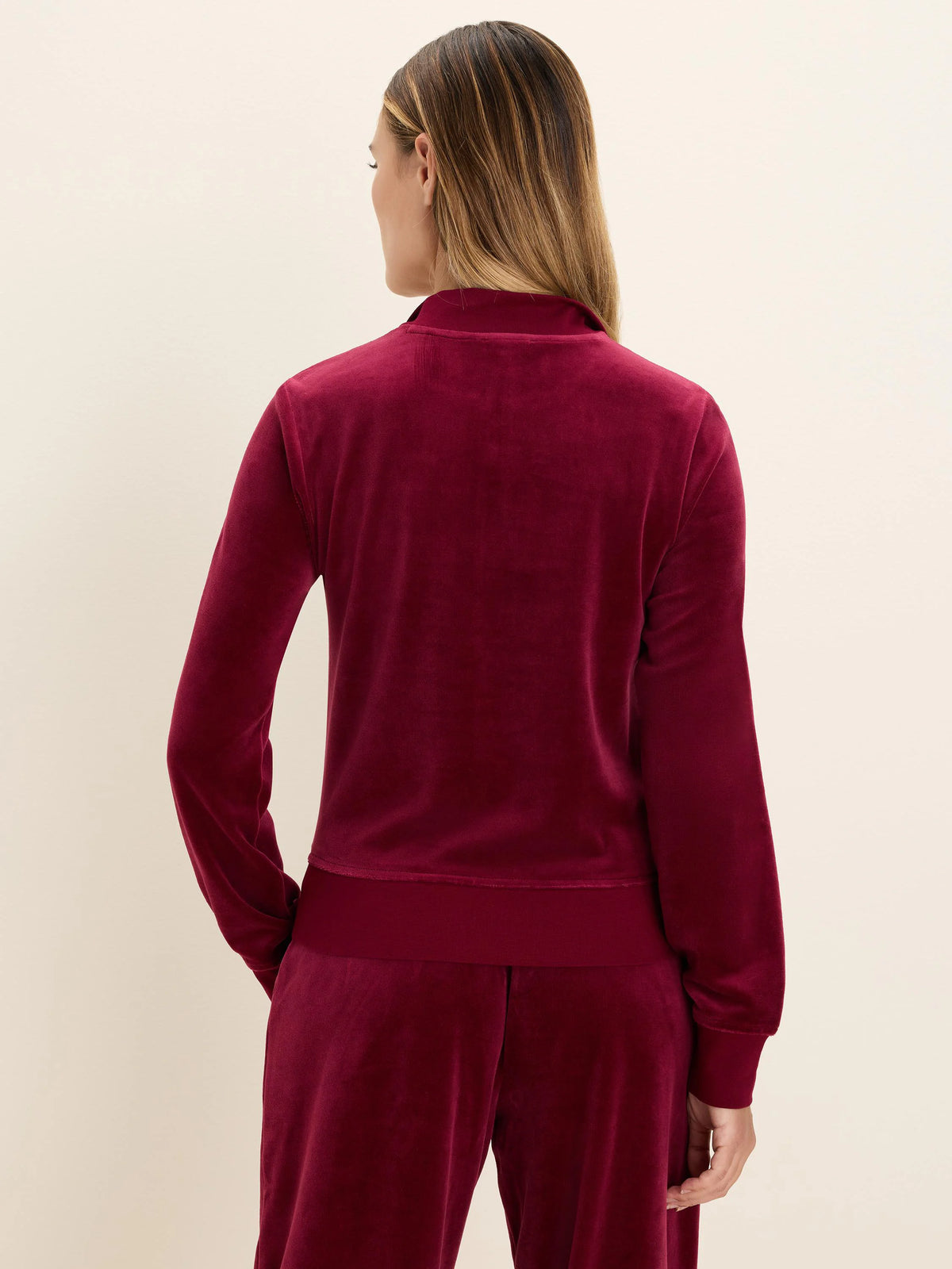 Deep red velour pullover, seen from back. Features mock neck, long sleeves with ribbed cuffs & hem.