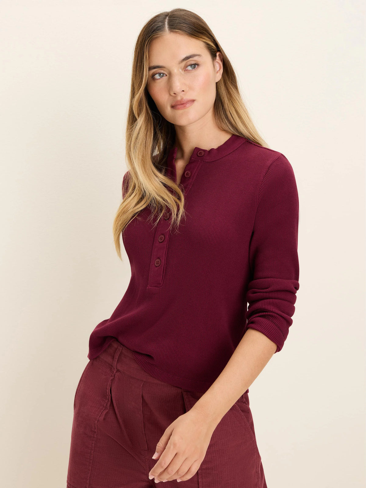 Burgundy long-sleeve thermal Henley top with waffle knit texture and three matching buttons at the neckline.