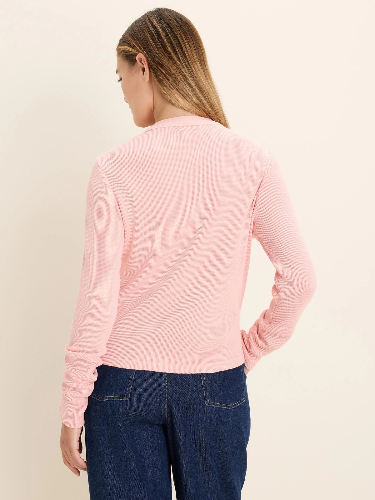 Light pink long-sleeved top with waffle knit texture, modeled from the back.