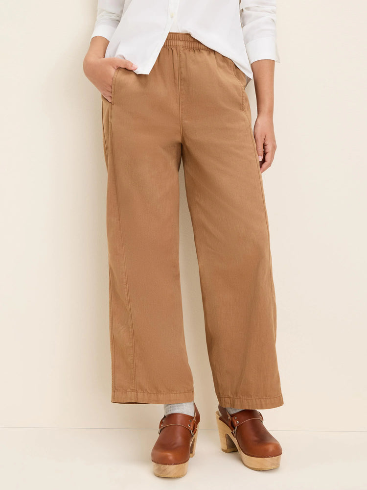 Camel wide-leg ankle pants featuring an elastic waist and prominent front seams.