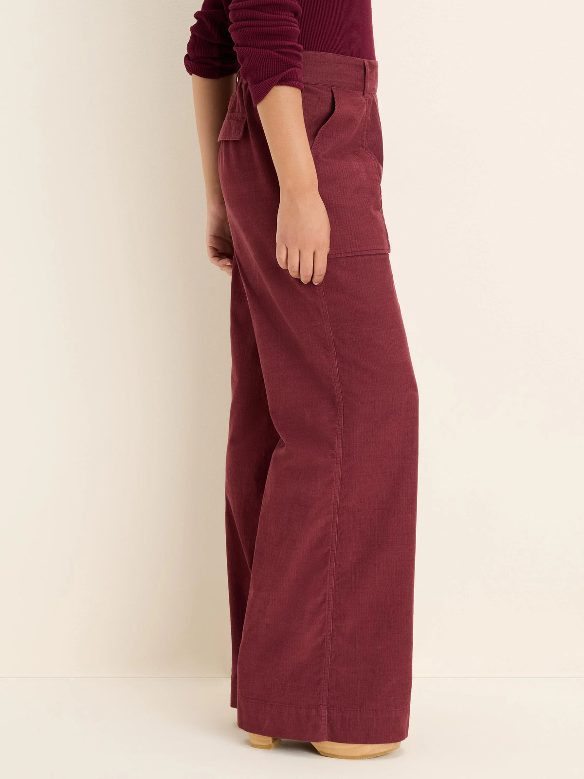 Burgundy wide-leg baby corduroy pants with front slash pockets and a thigh cargo pocket.