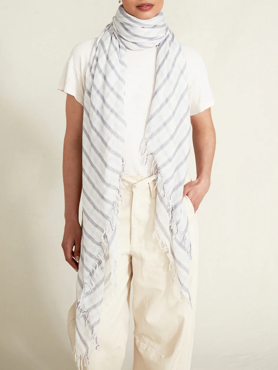White scarf with light grey diagonal stripes and frayed edges.