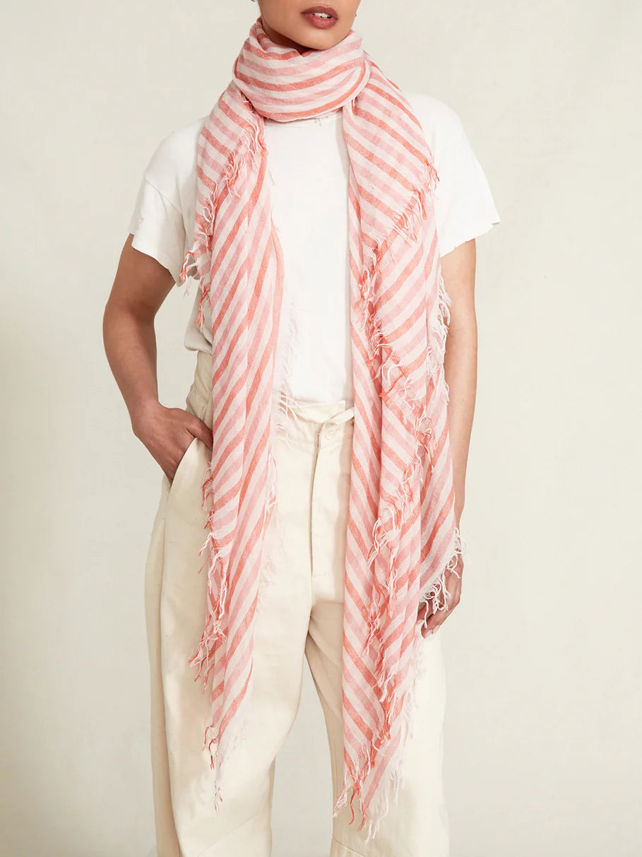 Pink and coral striped fringed scarf. Diagonal stripes on a lightweight fabric with frayed edges.